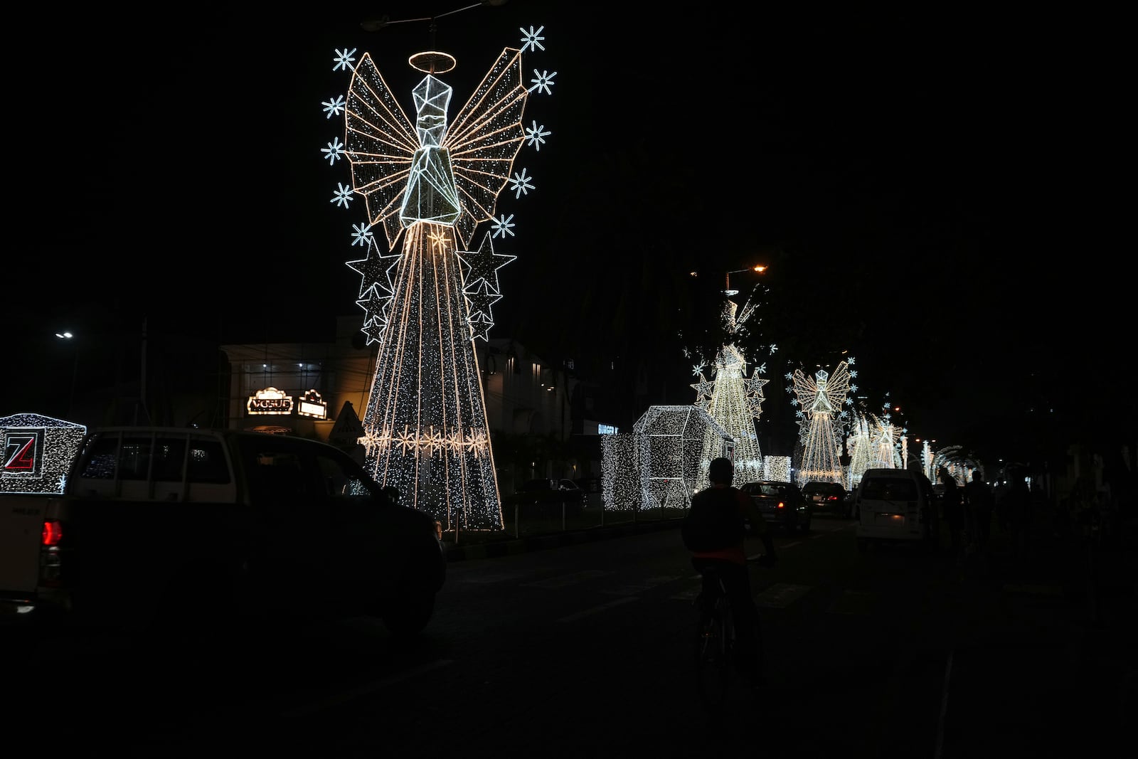 Cars drive past Christmas decorations on a street in Lagos, Nigeria, Friday, Dec. 20, 2024. (AP Photo/Sunday Alamba)