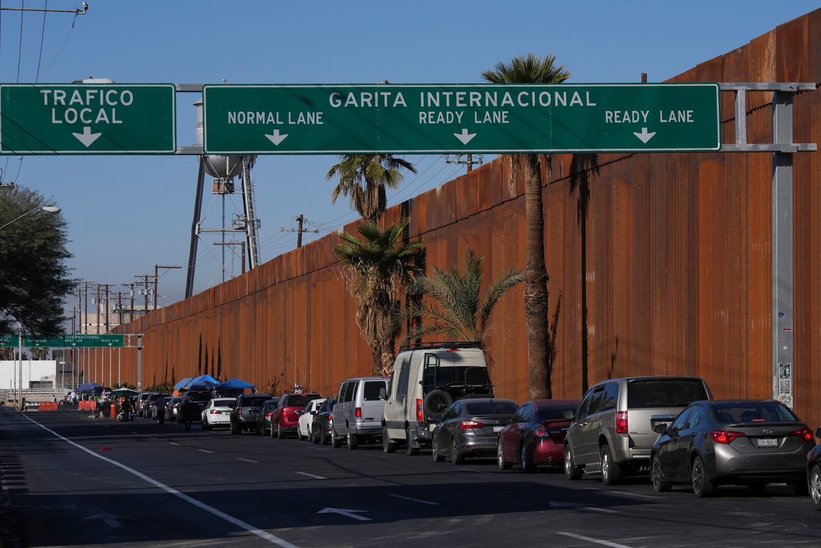 Drivers wait in line to enter to U.S, in Mexicali, Mexico, Saturday, Feb. 1, 2025. (AP Photo/Fernando Llano)