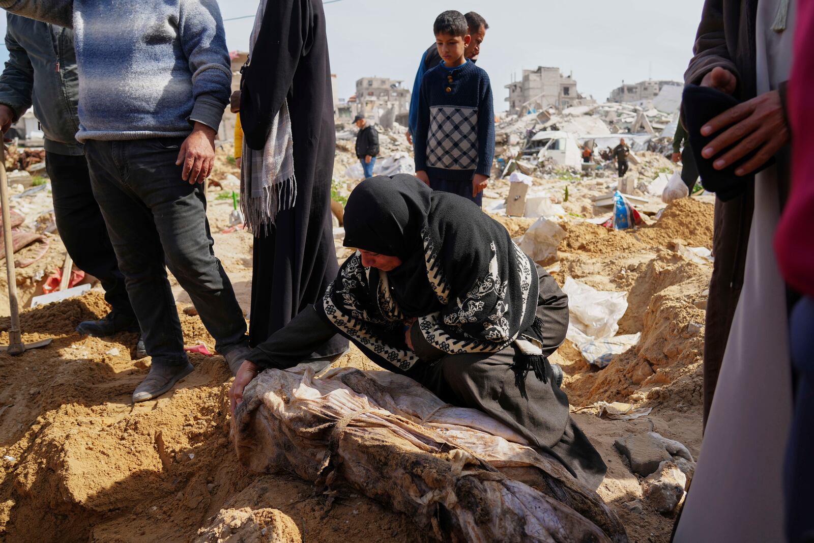 The bodies of Palestinians killed during the Israel-Hamas war and were buried in a mass grave at Shifa Hospital yard are exhumed for identification and reburial in Gaza City's official cemeteries, on Thursday, March 13, 2025. (AP Photo/Abdel Kareem Hana)