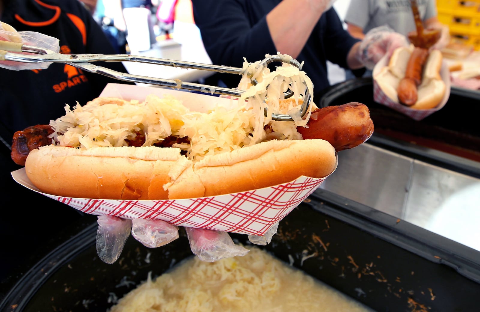 A giant hot dog is topped with sauerkraut at one of the many food booths at the Sauerkraut Festival in Waynesville.