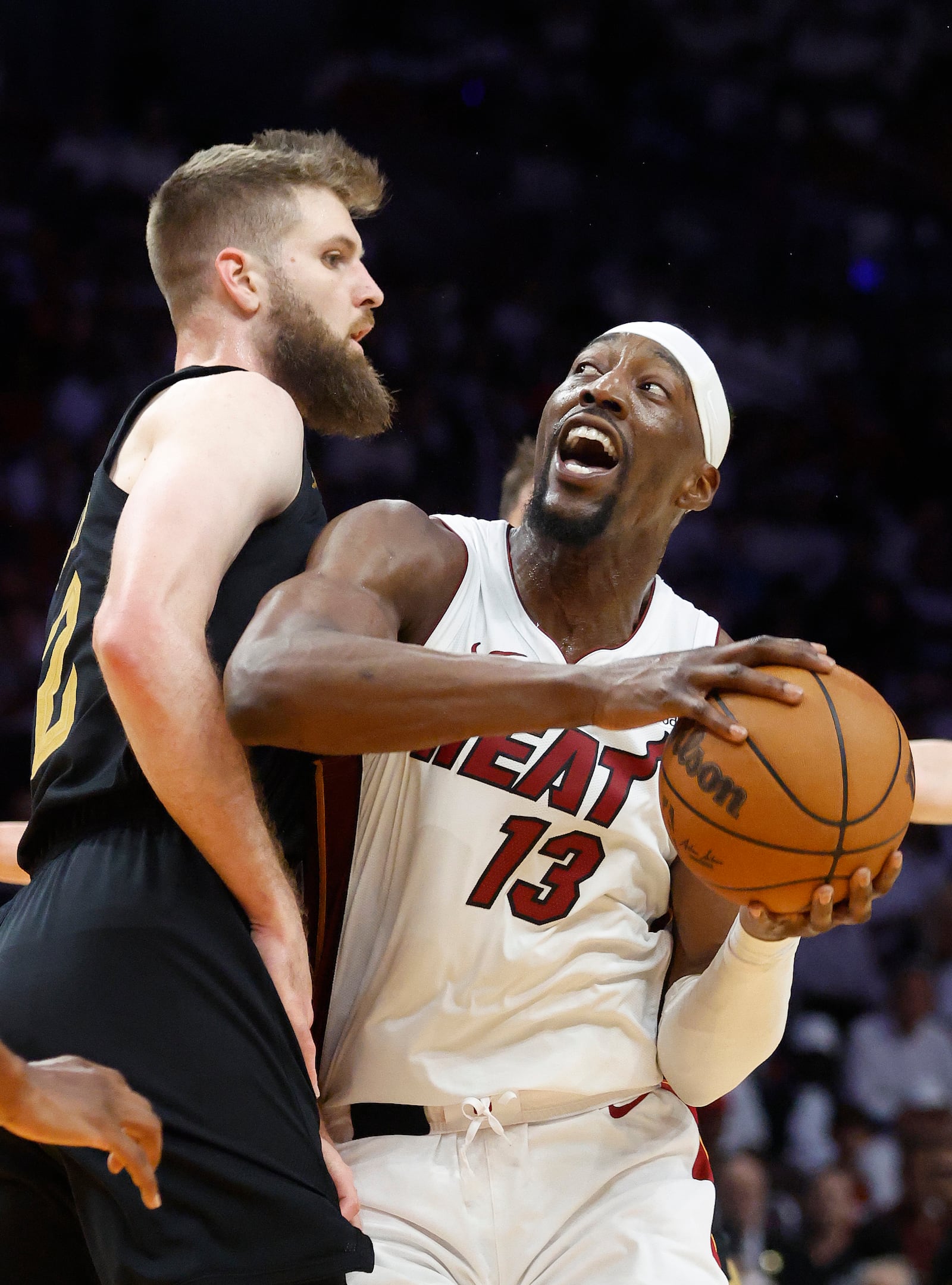Cleveland Cavaliers forward Dean Wade, left, defends against Miami Heat center Bam Adebayo (13) during the first half in Game 4 of an NBA basketball first-round playoff series, Monday, April 28, 2025, in Miami. (AP Photo/Rhona Wise)