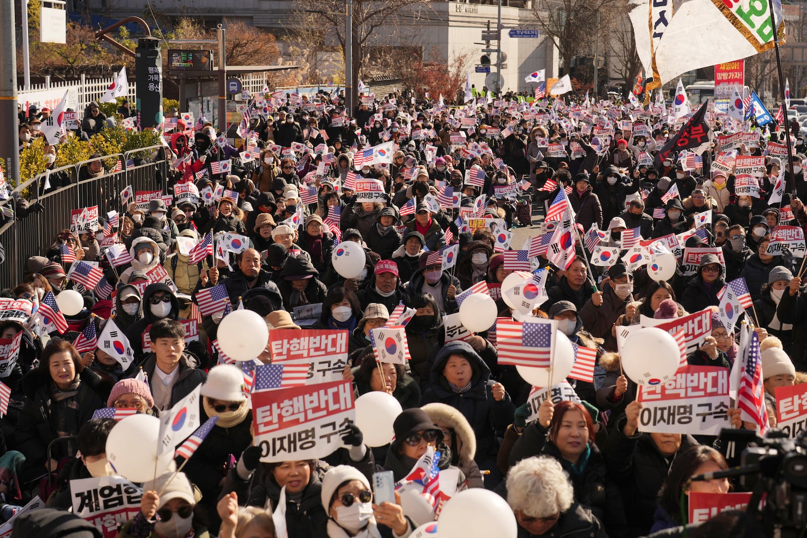 Supporters of impeached South Korean President Yoon Suk Yeol stage a rally near the presidential residence in Seoul, South Korea, Tuesday, Dec. 31, 2024. The letters read "Oppose Impeachment," and "Arrest Lee Jae-myung." (AP Photo/Lee Jin-man)