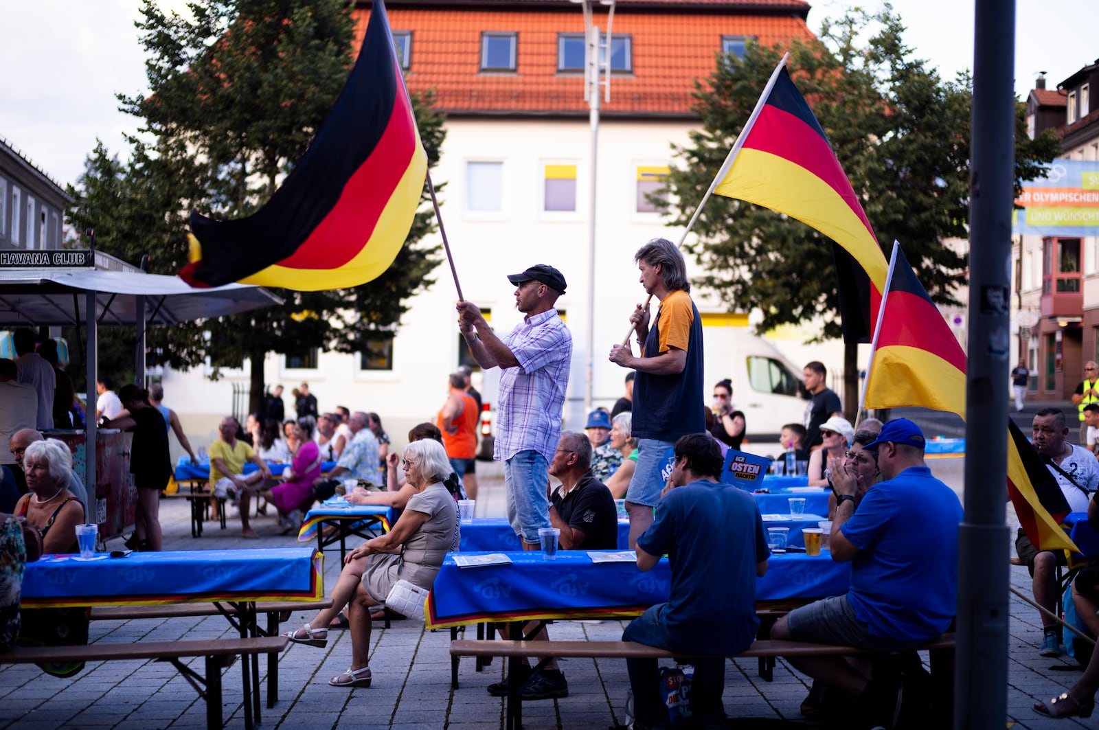 FILE - Supporters of the far-right Alternative for Germany party, or AfD, hold German national flags as they attend an election campaign rally of the party for upcoming state elections, in Suhl, Germany, Aug. 13, 2024. (AP Photo/Markus Schreiber, File)