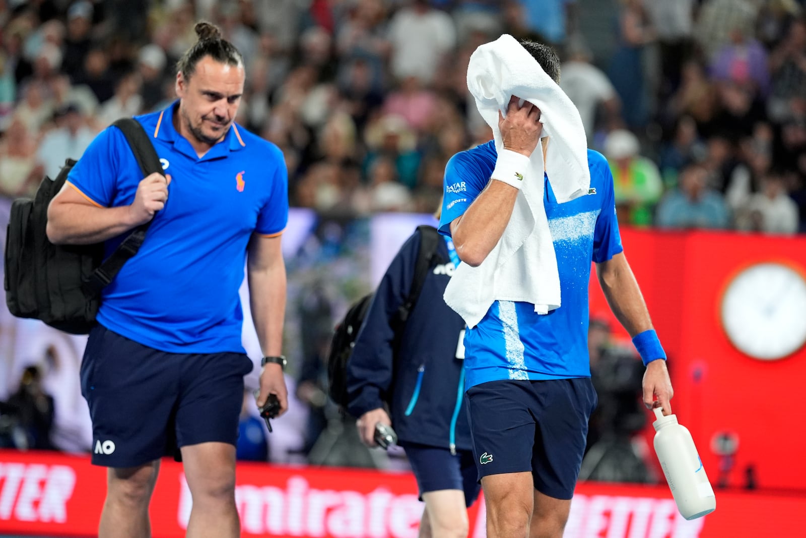 Novak Djokovic of Serbia walks from the court for a medical timeout during his quarterfinal match against Carlos Alcaraz of Spain at the Australian Open tennis championship in Melbourne, Australia, Tuesday, Jan. 21, 2025. (AP Photo/Asanka Brendon Ratnayake)