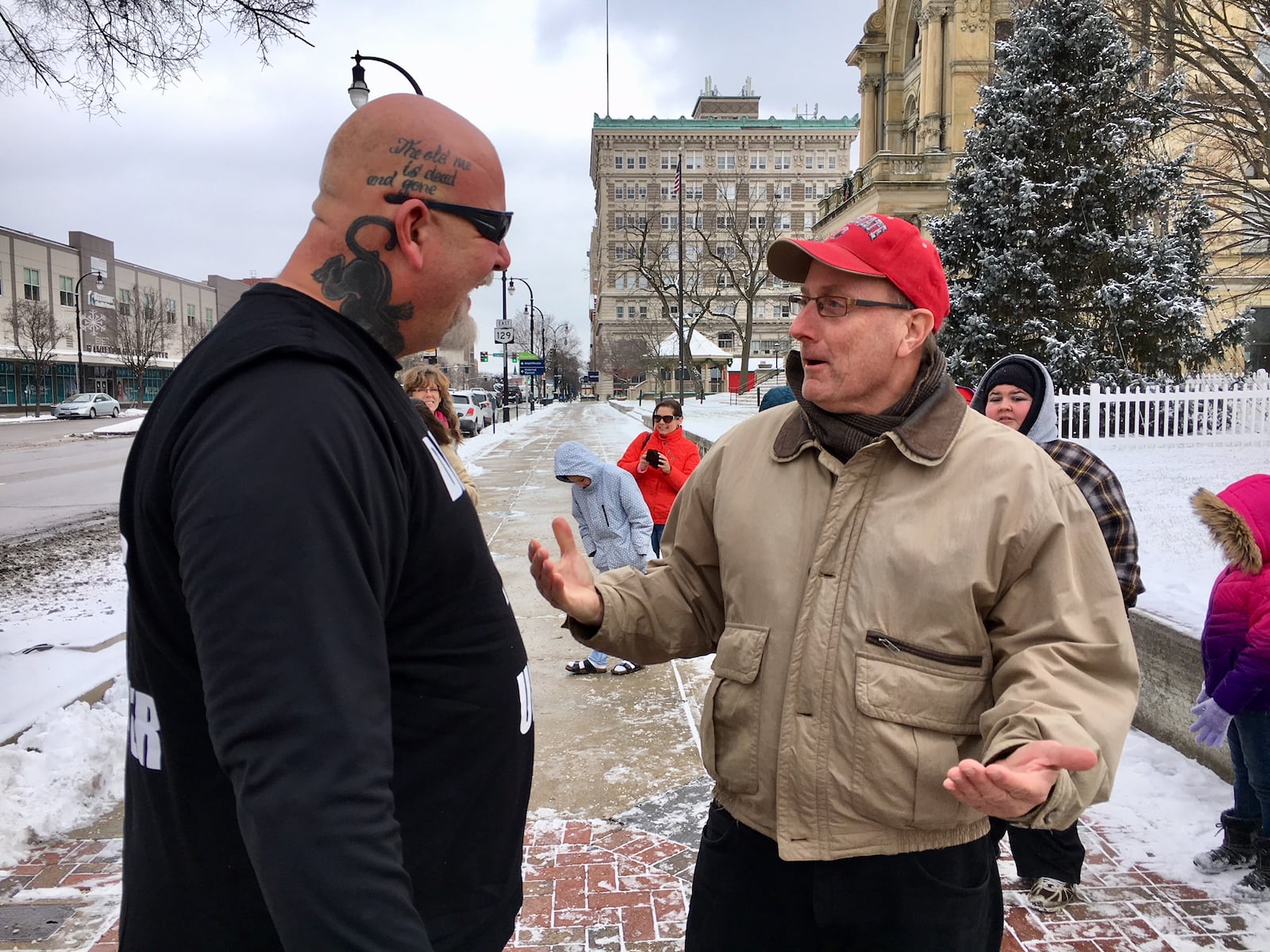 More than 60 area residents braved frigid cold Saturday to join hands in unity formation at the urging of the Hamilton City’s popular “Dancing Trucker.” Among the supporters of John Drury (left) was Hamilton Mayor Pat Moeller.(Photo by Michael D. Clark)