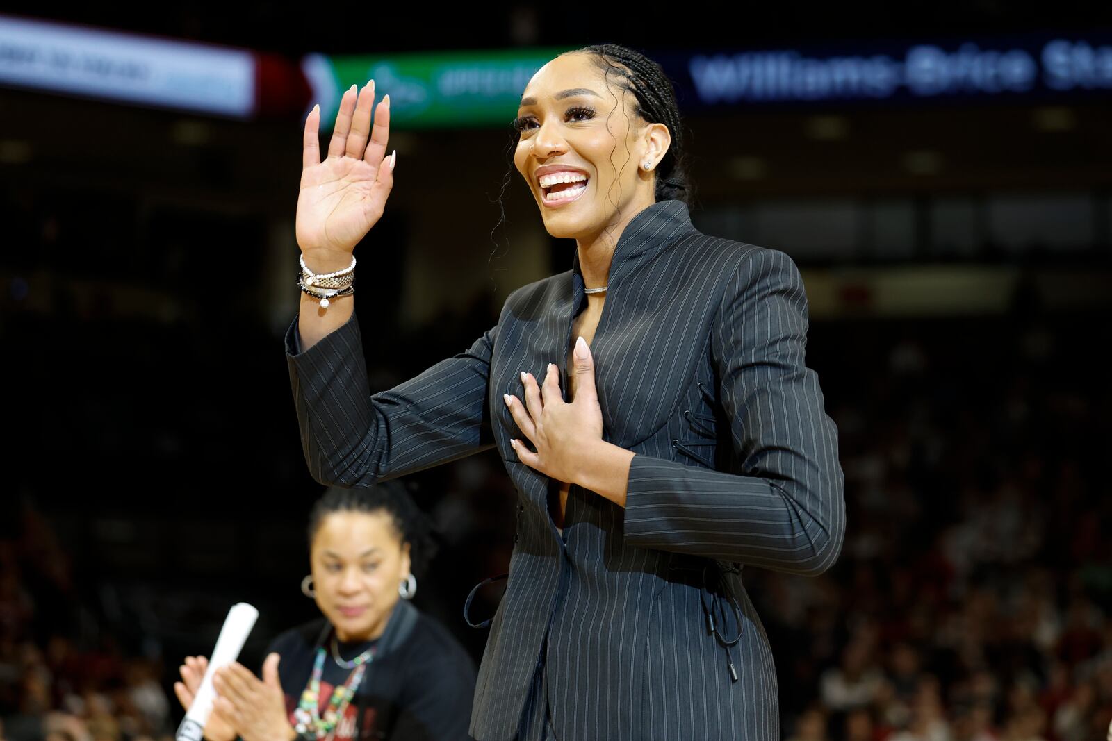 A'ja Wilson, center, stands with her parents Eva and Roscoe Wilson as they watch her number be retired during a ceremony before an NCAA college basketball game between South Carolina and Auburn in Columbia, S.C., Sunday, Feb. 2, 2025. (AP Photo/Nell Redmond)