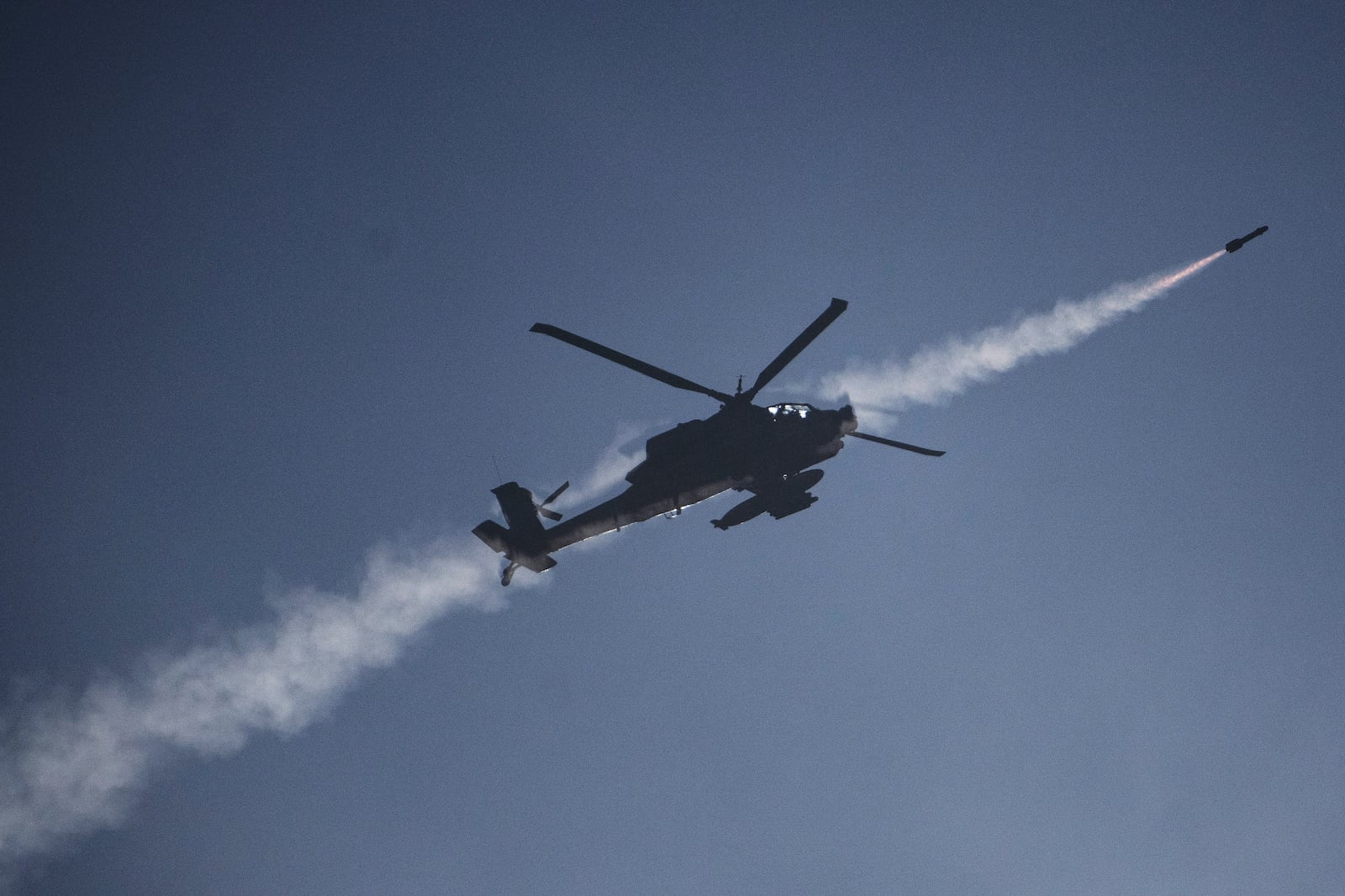 An Israeli Apache helicopter fires a missile towards southern Lebanon as seen from northern Israel, Sunday, Oct. 13, 2024. (AP Photo/Leo Correa)