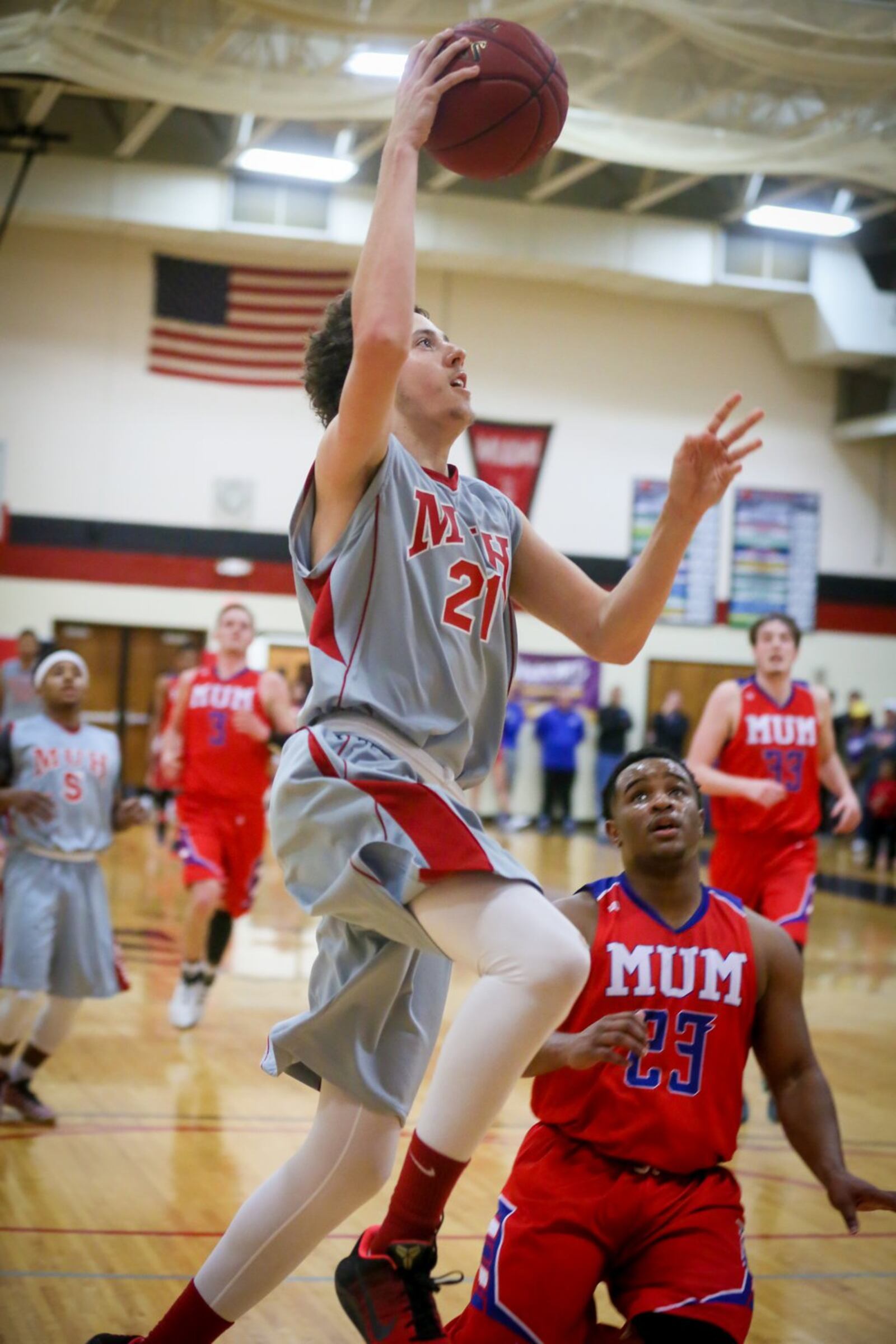 Miami Hamilton guard Jacob Hiler (21) drives past Miami Middletown’s Germain Britten and toward the basket during Wednesday night’s game at MUH. GREG LYNCH/STAFF