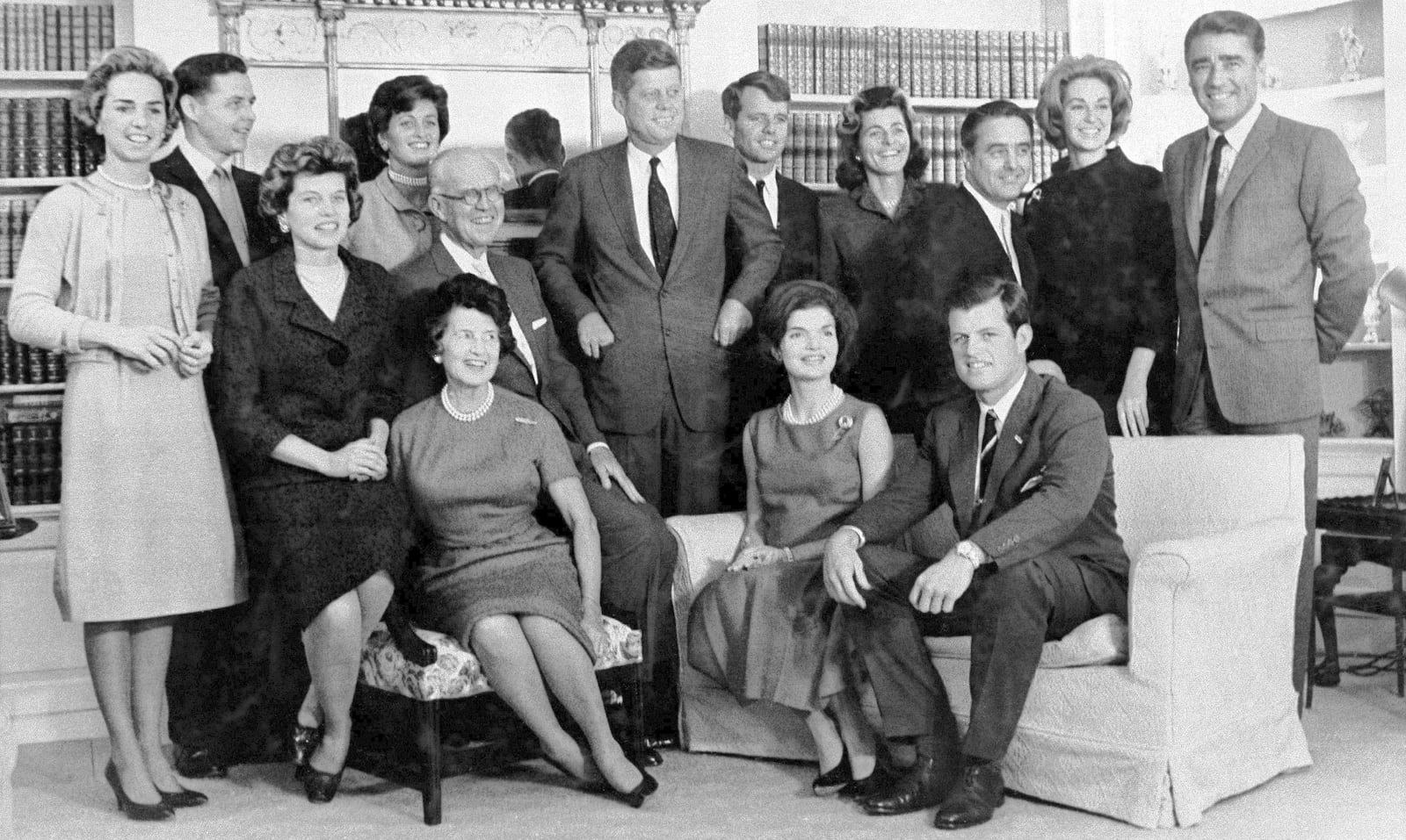 FILE - Then President-elect John F. Kennedy, standing at center, is surrounded by members of his family in the home of his parents in December 1960, in Hyannis Port, Mass. Standing, Ethel Kennedy, from left, wife of Robert Kennedy, Steven Smith and wife Jean Kennedy Smith, Robert Kennedy, Patricia Kennedy Lawford, Sargent Shriver, Joan Kennedy, wife of Edward Kennedy, and Peter Lawford, and in foreground, Eunice Kennedy Shriver, from left, Joseph P. Kennedy and wife Rose Kennedy, seated in front, Jacqueline Kennedy, and Edward Kennedy. (AP Photo, File)