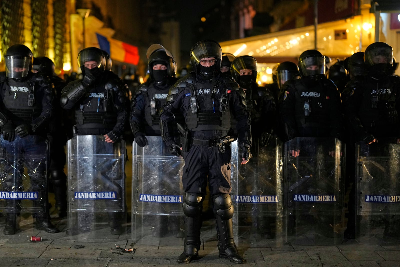 Police form a line in front of supporters of Calin Georgescu who were protesting after Romania's electoral body rejected his candidacy in the presidential election rerun in Bucharest, Romania, Sunday, March 9, 2025. (AP Photo/Vadim Ghirda)