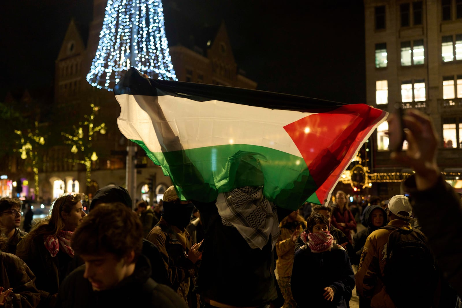 A pro-Palestinian protestor holds a Palestinian flag at a demonstration in Amsterdam, Netherlands, Wednesday, Nov. 13, 2024, despite a city ban on such gatherings. (AP Photo/Bram Janssen)