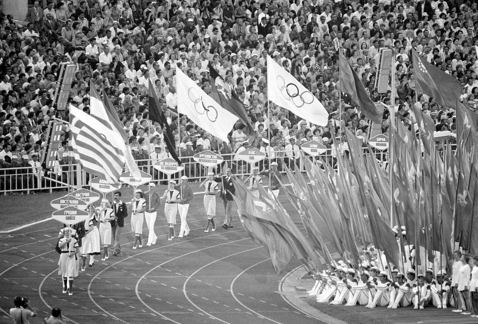 FILE - Flag and sign bearers march around Moscow's Lenin Stadium during closing ceremonies of the XXII Summer Olympic Games in Moscow, on Aug. 3, 1980. (AP Photo/File)