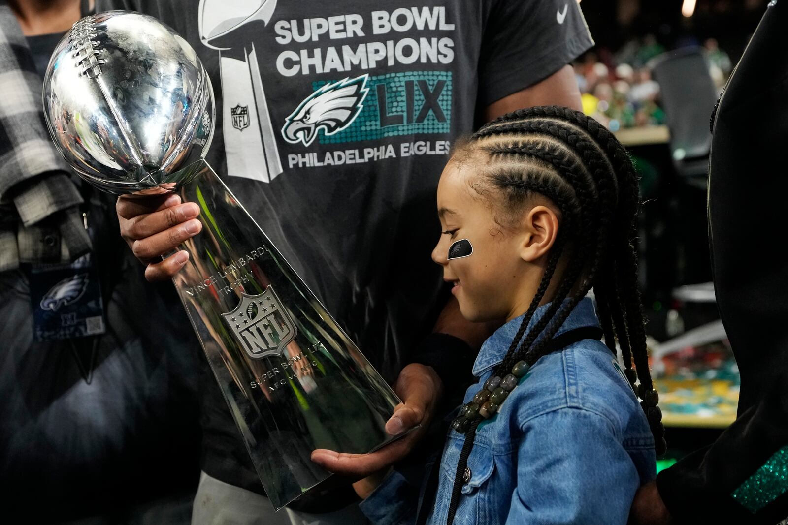 Philadelphia Eagles running back Saquon Barkley's daughter Jada looks at the Vince Lombardi Trophy after the NFL Super Bowl 59 football game against the Kansas City Chiefs, Sunday, Feb. 9, 2025, in New Orleans. (AP Photo/Ashley Landis)