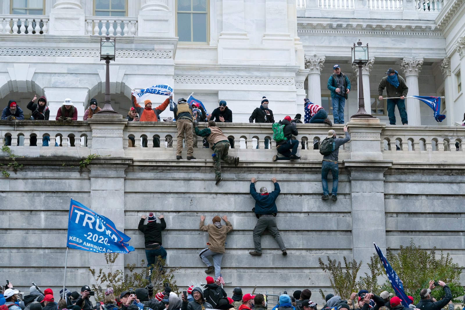 FILE - Supporters of President Donald Trump climb the west wall of the the U.S. Capitol in Washington, Jan. 6, 2021. (AP Photo/Jose Luis Magana, File)