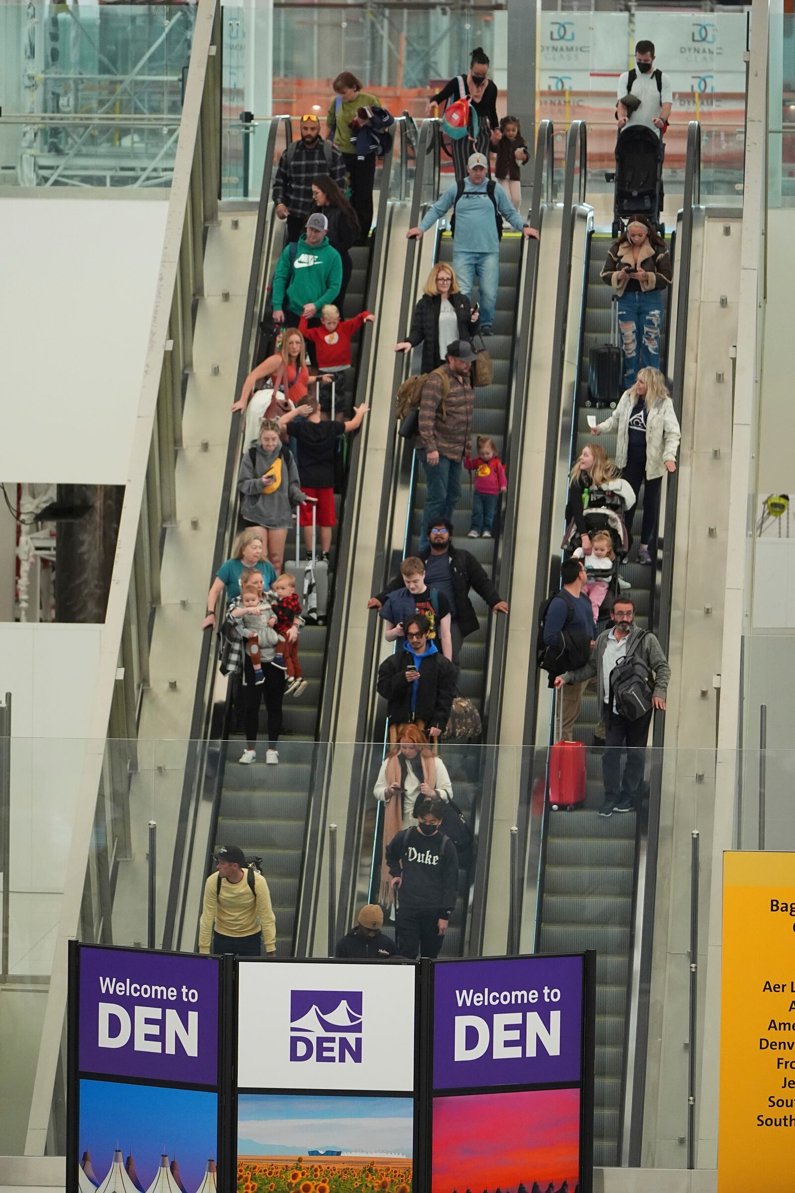 Travellers ride an escalator to the shuttle trains to the concourses in Denver International Airport Tuesday, Nov. 26, 2024, in Denver. (AP Photo/David Zalubowski)