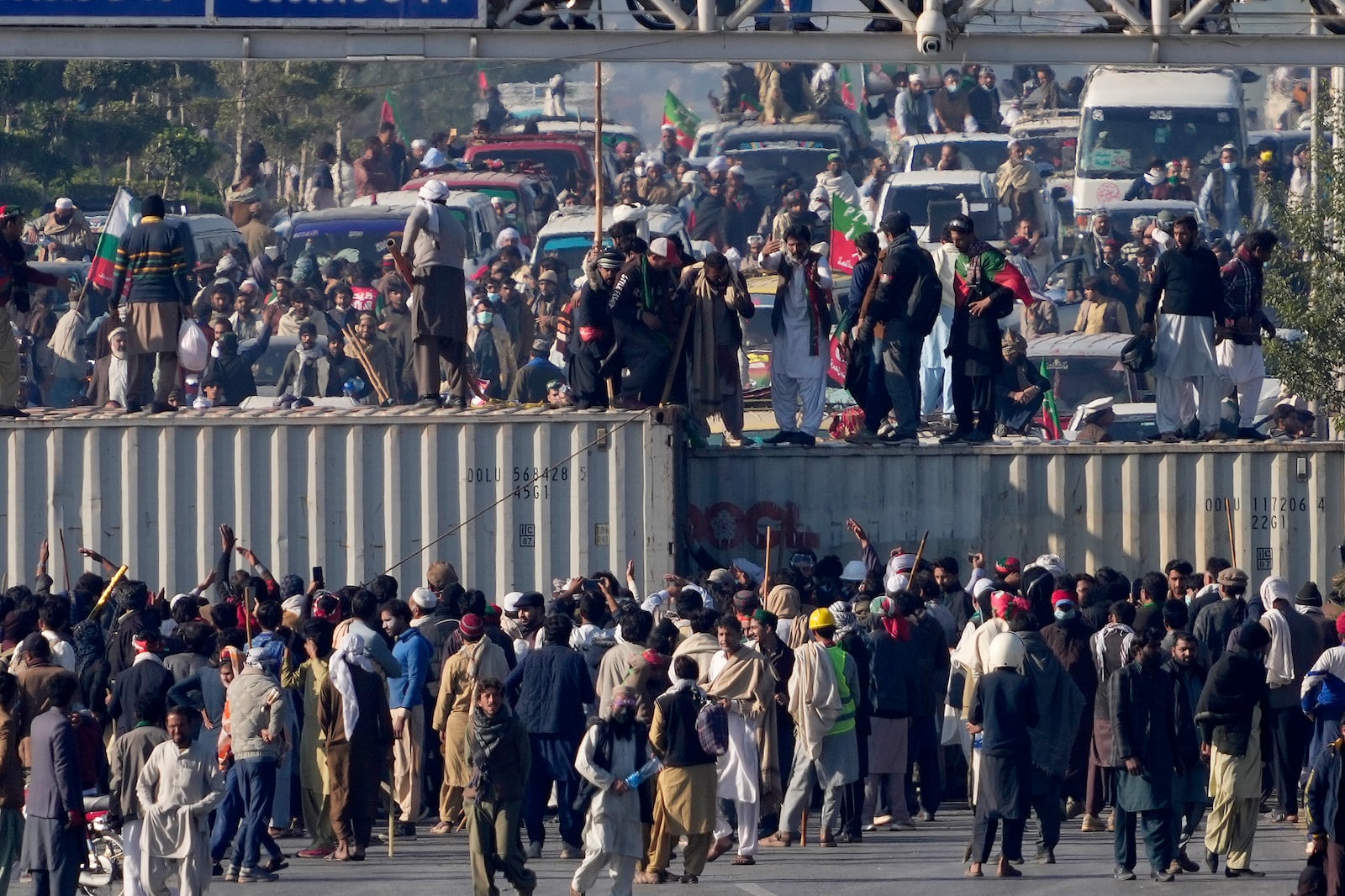 Supporters of imprisoned former premier Imran Khan's Pakistan Tehreek-e-Insaf party, remove shipping container to clear way for their rally demanding Khan's release, in Islamabad, Pakistan, Tuesday, Nov. 26, 2024. (AP Photo/Anjum Naveed)