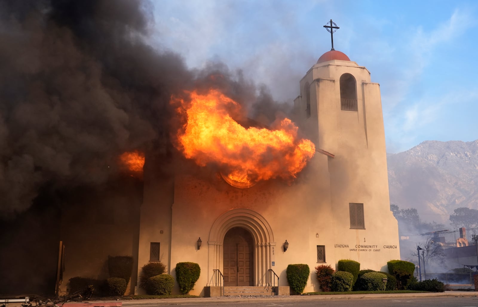 Fire explodes out of a window of the Altadena Community Church, Wednesday, Jan. 8, 2025, in the downtown Altadena section of Pasadena, Calif. (AP Photo/Chris Pizzello)