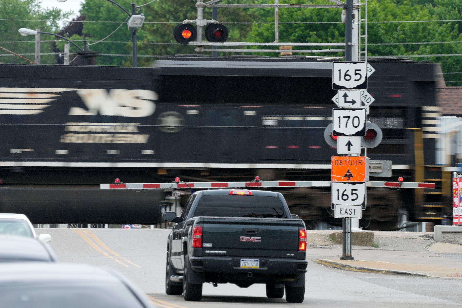 FILE - Traffic backs up as a Norfolk Southern freight train rolls through a crossing in downtown East Palestine, Ohio, on June 22, 2023. (AP Photo/Gene J. Puskar, File)