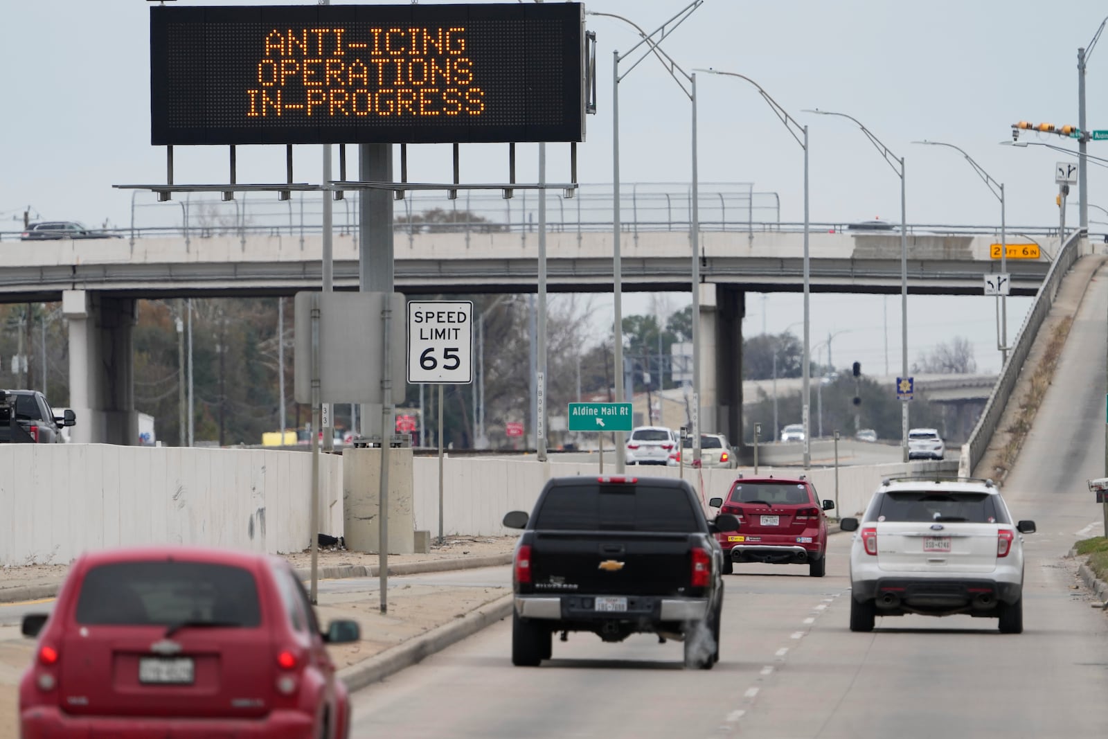 Vehicles pass a sign displaying Winter storm related operations Monday, Jan. 20, 2025, in Houston, ahead of predicted several inches of snow and possibly ice in Southeast Texas. (AP Photo/David J. Phillip