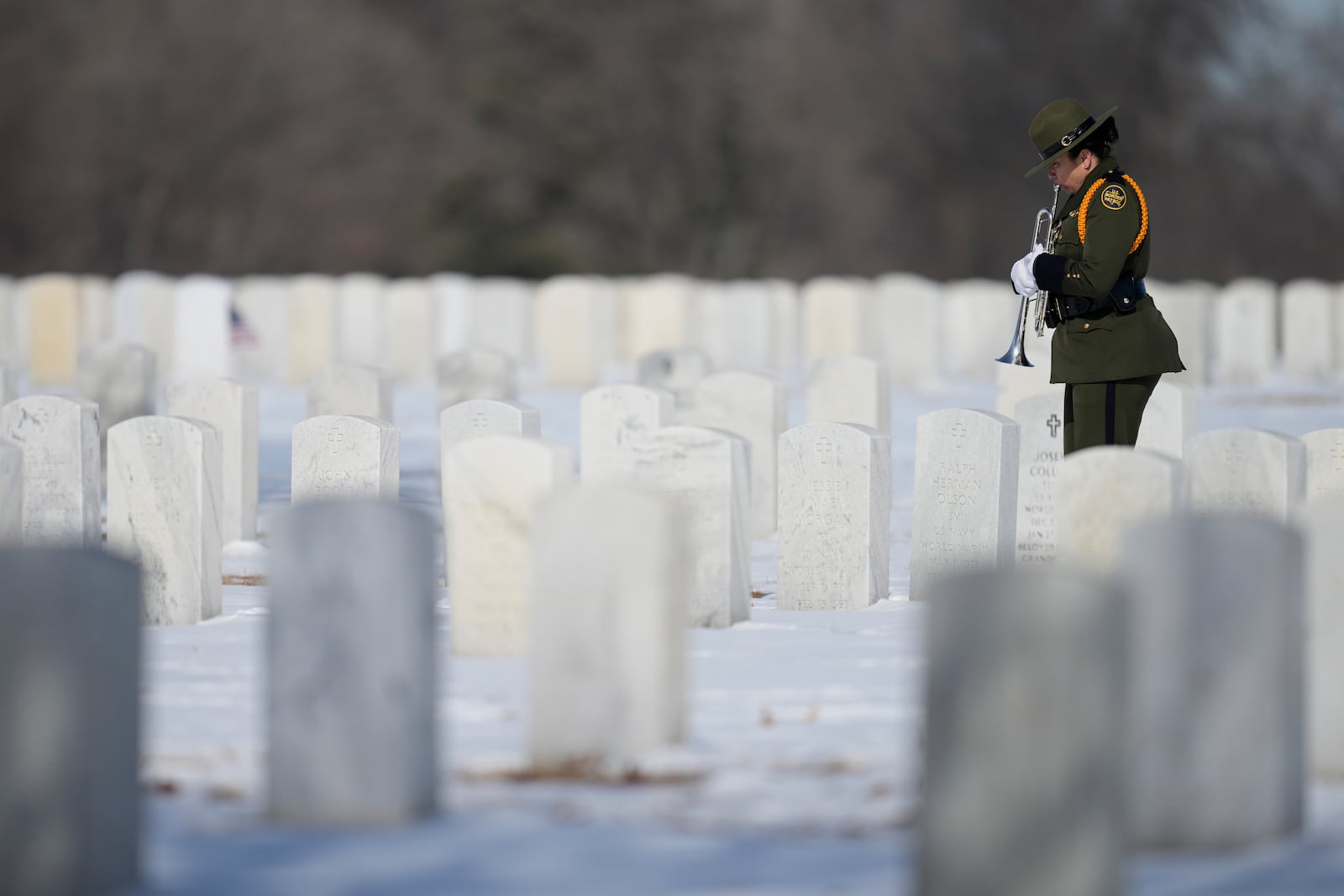 A U.S. Border Patrol member plays trumpet before a service for U.S. Border Patrol agent David Maland to be recognized with military honors before his burial at Fort Snelling National Cemetery in Minneapolis, on Saturday, Feb. 22, 2025. (AP Photo/Abbie Parr)