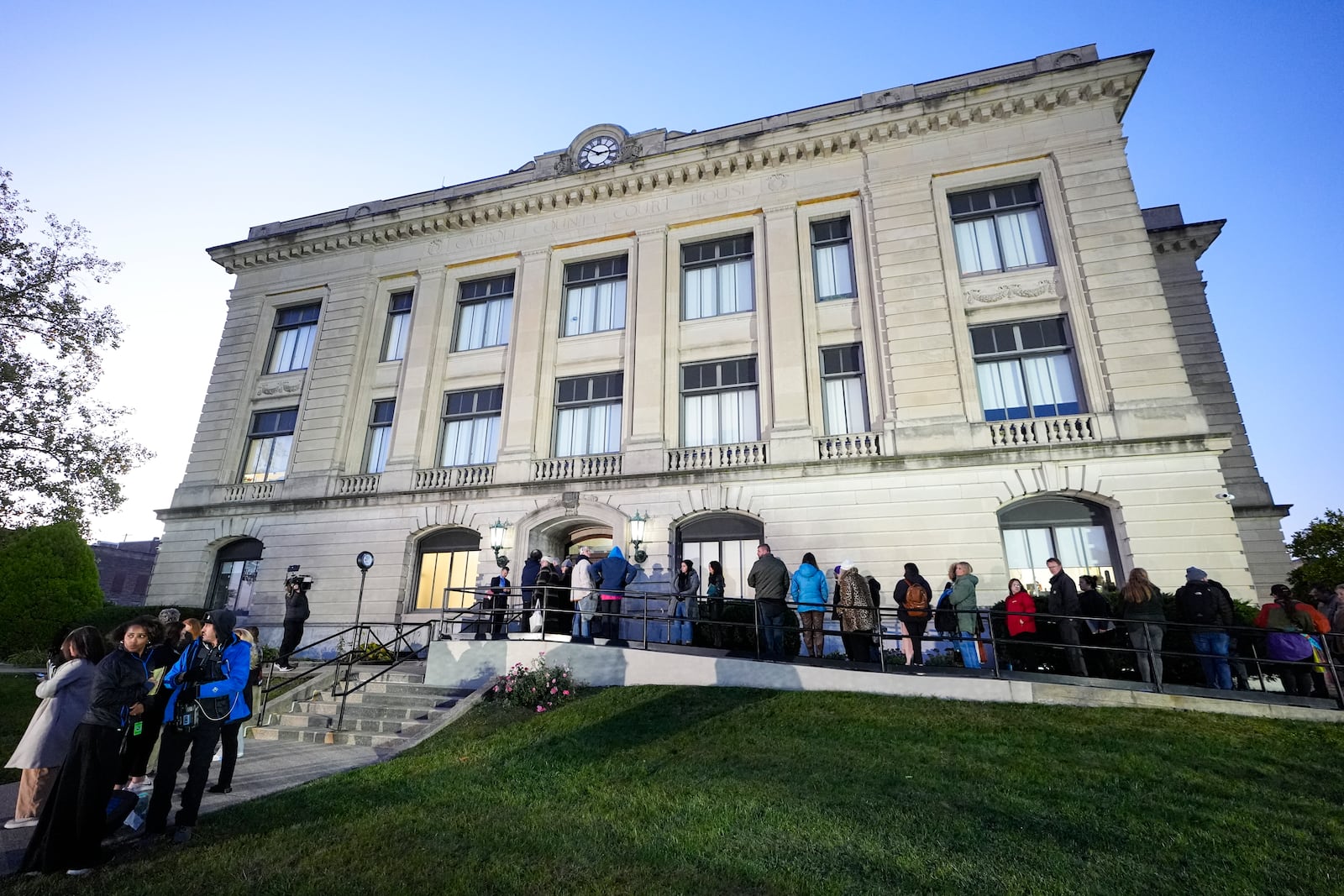 Spectators line up to enter the Carroll County Courthouse for the trail of Richard Allen, accused of the slayings of two teenage girls in 2017, is set to begin in Delphi, Ind., Friday, Oct. 18, 2024. (AP Photo/Michael Conroy)