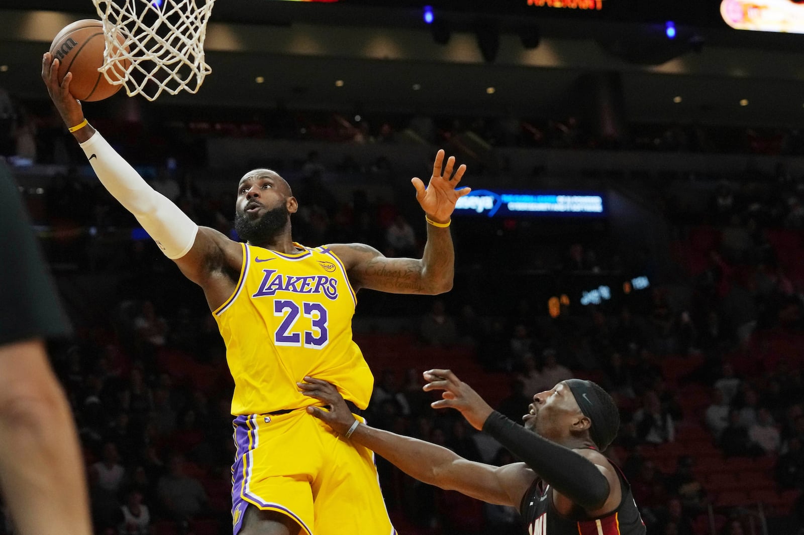 Los Angeles Lakers forward LeBron James (23) aims to score over Miami Heat center Bam Adebayo during the first half of an NBA basketball game, Wednesday, Dec. 4, 2024, in Miami. (AP Photo/Marta Lavandier)