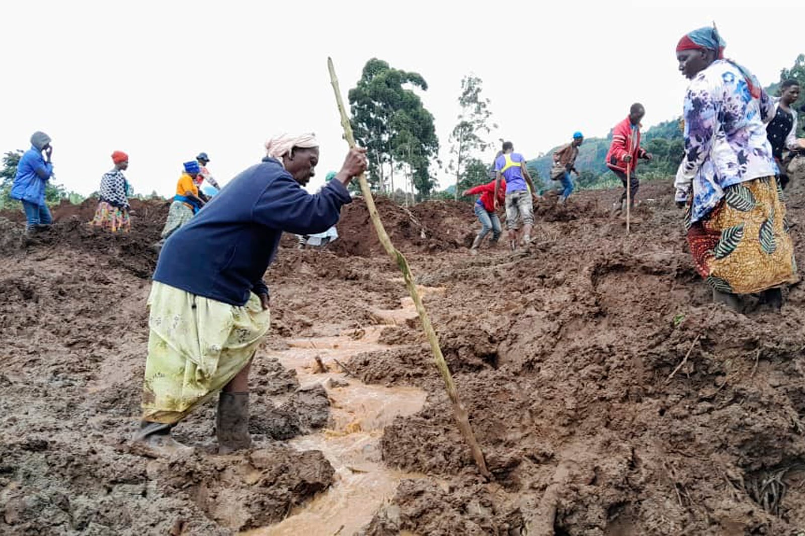 Rescue workers and people search for bodies after landslides following heavy rains buried 40 homes in the mountainous district of Bulambuli, eastern Uganda, Thursday, Nov. 28. 2024. (AP Photo/Jean Watala)