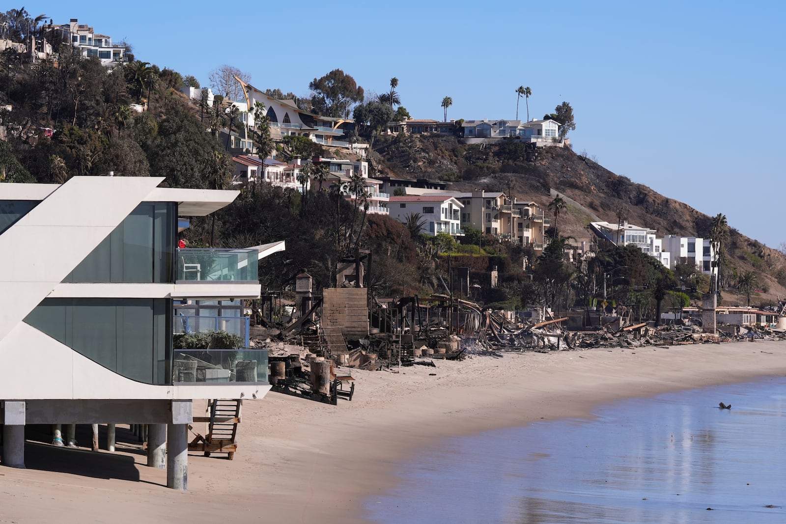 A home stands next to properties destroyed by the Palisades Fire in Malibu, Calif., Sunday, Jan. 12, 2025. (AP Photo/Mark J. Terrill)