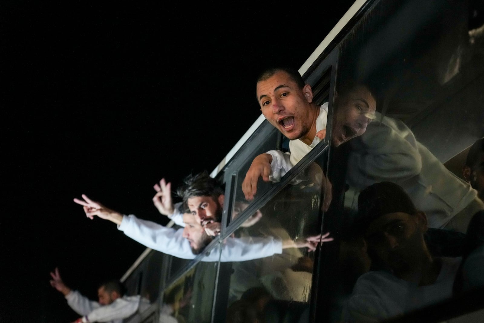 Freed Palestinian prisoners wave from a bus as they arrive in the Gaza Strip after being released from an Israeli prison following a ceasefire agreement between Hamas and Israel in Khan Younis, Gaza Strip, Thursday, Feb. 27, 2025. (AP Photo/Abdel Kareem Hana)