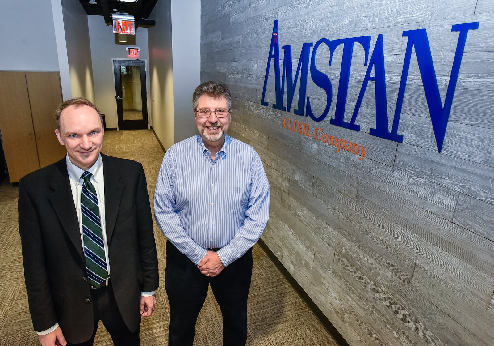 Mark Bunting, president of Amstan, left, and Ron Grosso, general manager, stand in Amstan Logistics headquarters that recently moved to Liberty Center. The company, a leading third-party logistics/freight management company, relocated their corporate headquarters to accommodate the growth of their business and attract top talent. NICK GRAHAM/STAFF