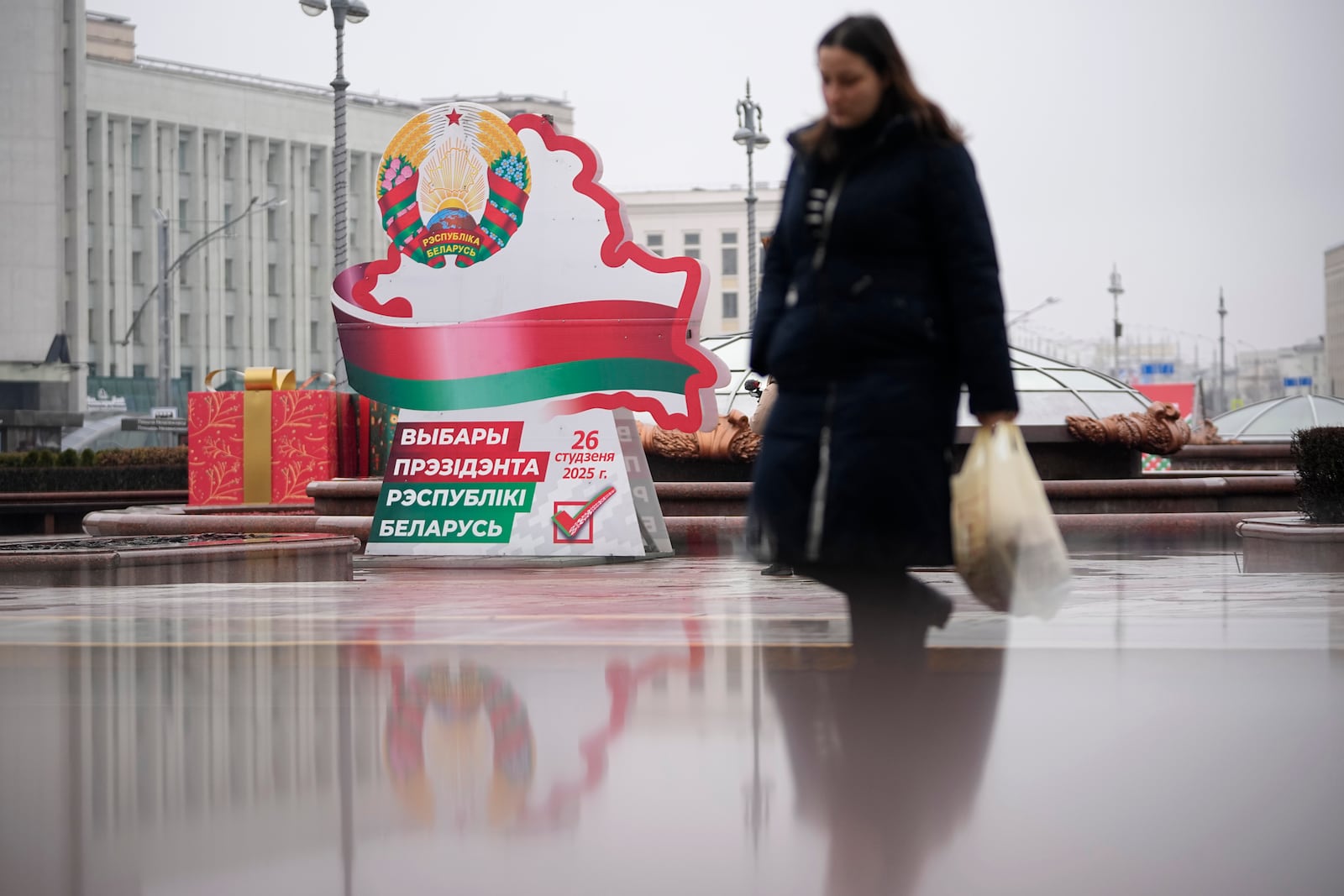 A woman walks past an election billboard ahead of presidential elections in Minsk, Belarus, Friday, Jan. 24, 2025. (AP Photo/Pavel Bednyakov)