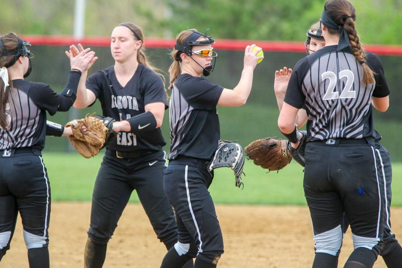 Lakota East’s Rachel Lewis (second from left) high-fives teammate Brianna Castner during a meeting in the circle on April 11, 2017, at Lakota West. The visiting Thunderhawks won 8-2. GREG LYNCH/STAFF