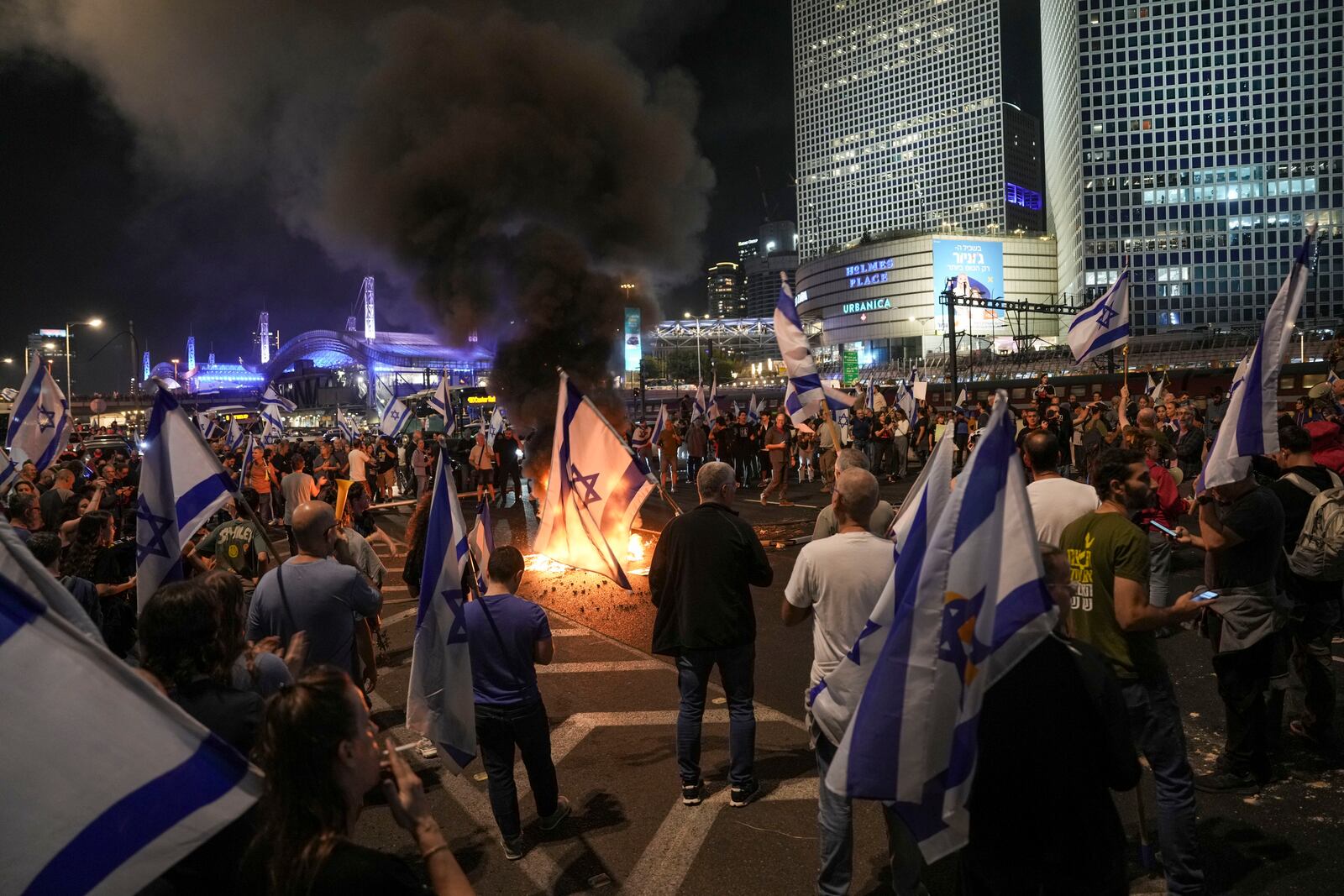 Israelis light a bonfire during a protest after Prime Minister Benjamin Netanyahu has dismissed his popular defense minister Yoav Gallant, in Tel Aviv, Israel, Tuesday, Nov. 5, 2024. (AP Photo/Oded Balilty)