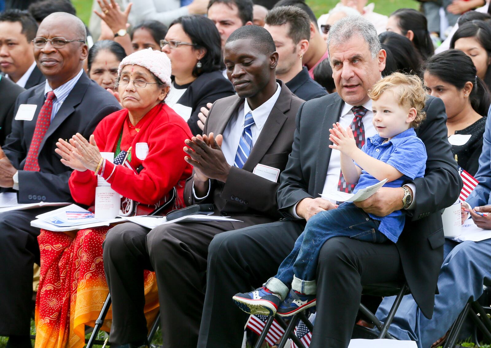 Miami University Regionals in Hamilton has created an annual celebration to where dozens of immigrants take a naturalization oath to become U.S. citizens. Pictured is Abraham Kajomovitz, from Mexico City, as he sits with his grandson, Adam Kerbel, as he participates in the naturalization ceremony on Thursday, Sept. 14, 2017, held in the quad at Miami University’s Hamilton campus. GREG LYNCH/FILE