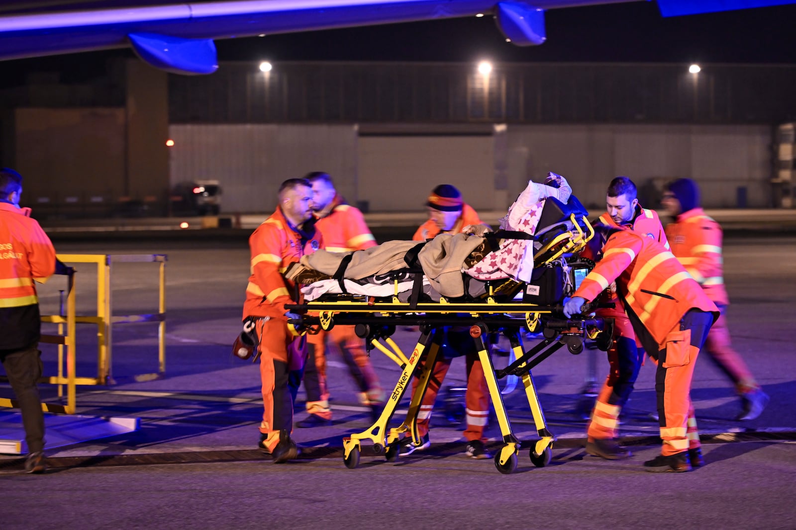 A patient is carried on a strecher by medical staff as survivors of the Kocani night club fire, treated with burn injuries, are transported to hospital upon arrival by a Hungarian Air Force MH Airbus A319 jet at the capital city's international airport in Budapest, Hungary, early Wednesday, March 19, 2025. (Peter Lakatos/MTI via AP)