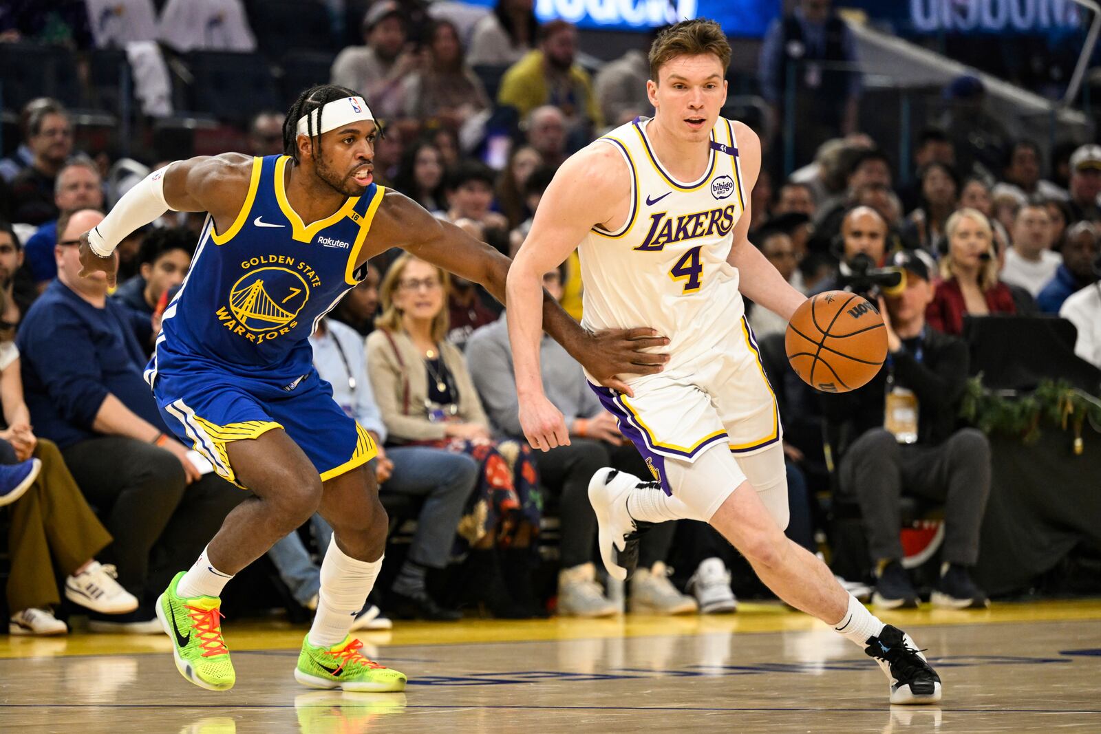 Los Angeles Lakers guard Dalton Knecht (4) dribbles against Golden State Warriors guard Buddy Hield (7) during the first half of an NBA basketball game, Wednesday, Dec. 25, 2024, in San Francisco. (AP Photo/Eakin Howard)