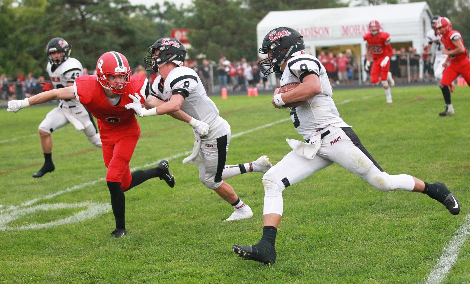 Franklin QB Braden Woods (with ball) gets an assist from Ryan Russell (2) against Madison defender Connor Blaylock. Franklin defeated host Madison 42-6 in a Week 1 high school football opener on Friday, Aug. 30, 2019. MARC PENDLETON / STAFF