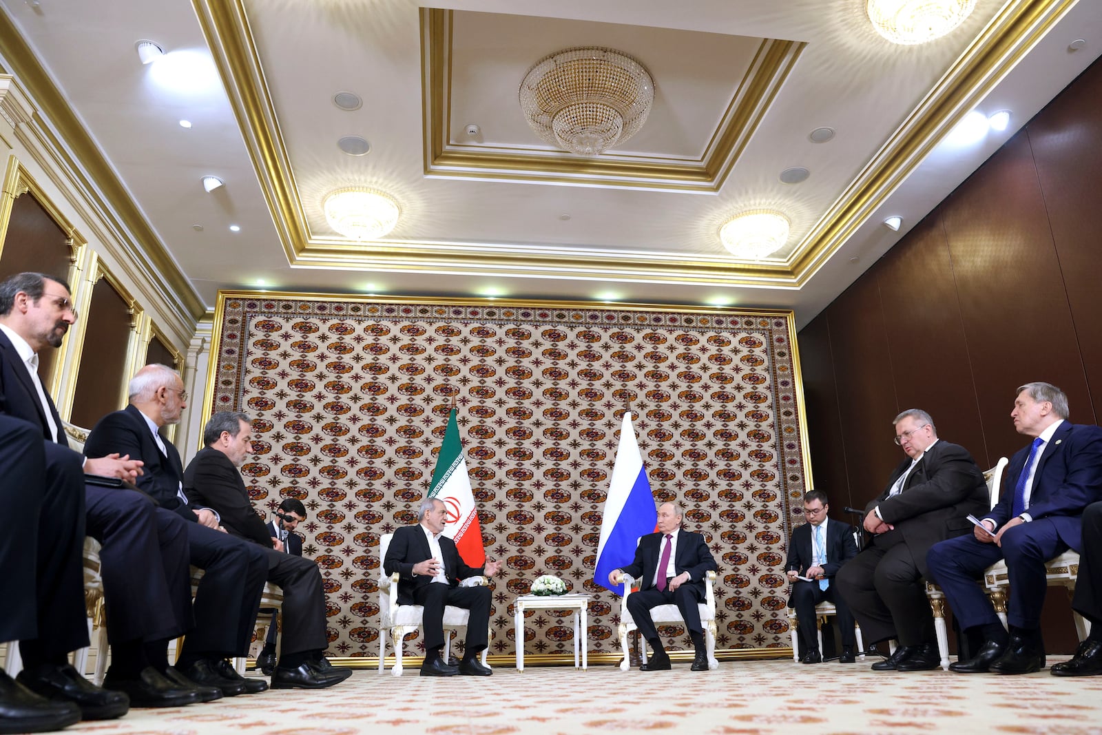 Russian President Vladimir Putin, background right, listens to Iranian President Masoud Pezeshkian, background left, during their meeting on the sidelines of the International Forum "The Interconnection of Times and Civilizations – the basis of peace and development" dedicated to the 300th anniversary of the birth of the outstanding Turkmen poet and thinker Magtymguly Fragi in Ashgabat, Turkmenistan, Friday, Oct. 11, 2024. (Alexander Shcherbak, Sputnik, Kremlin Pool Photo via AP)