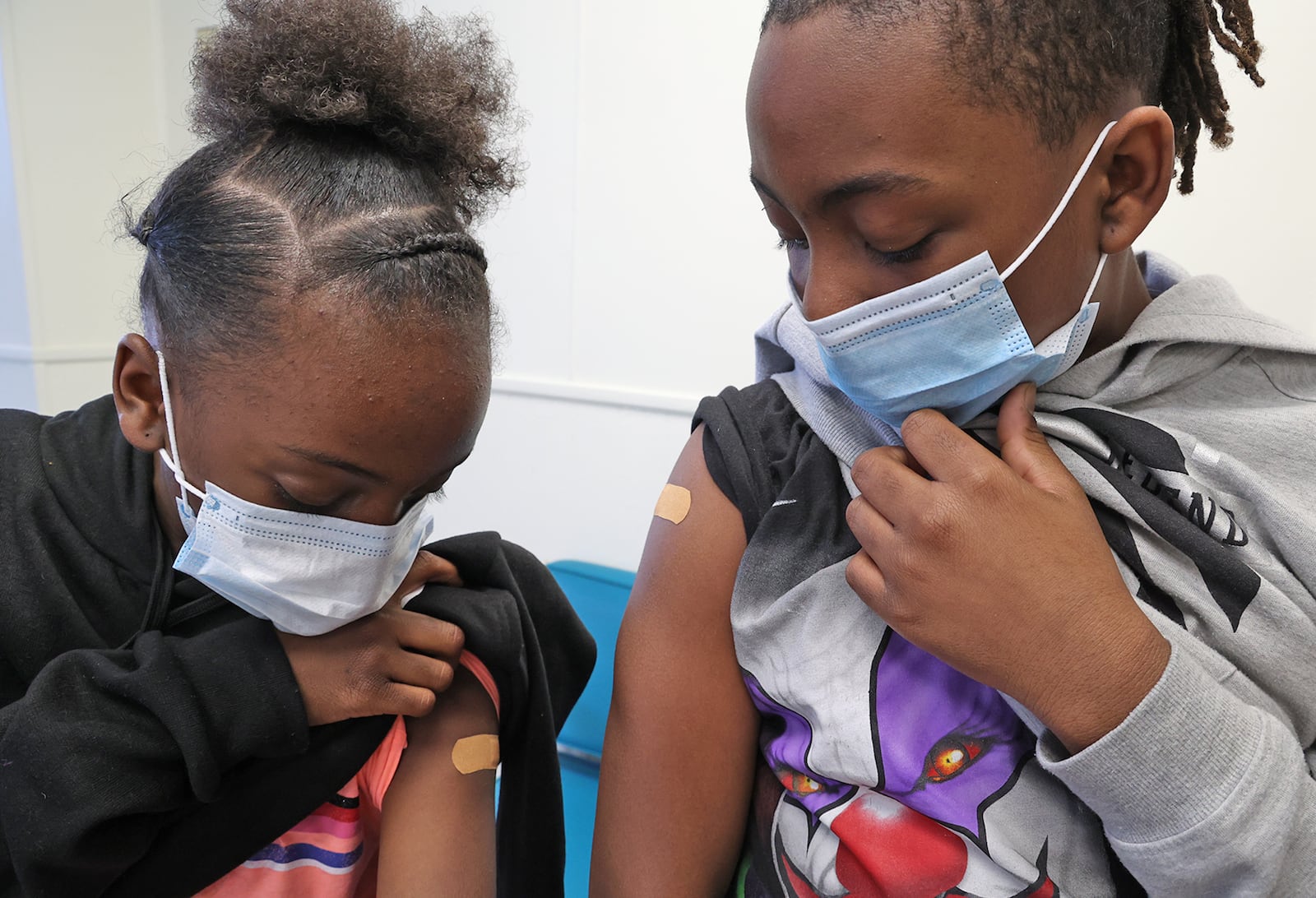 Ta'Niah Walker, 9, and her brother, Terrance, 11, check out where they got their COVID vaccine injections Friday, Feb. 25, 2022 at the Clark County Combined Health District. BILL LACKEY/STAFF