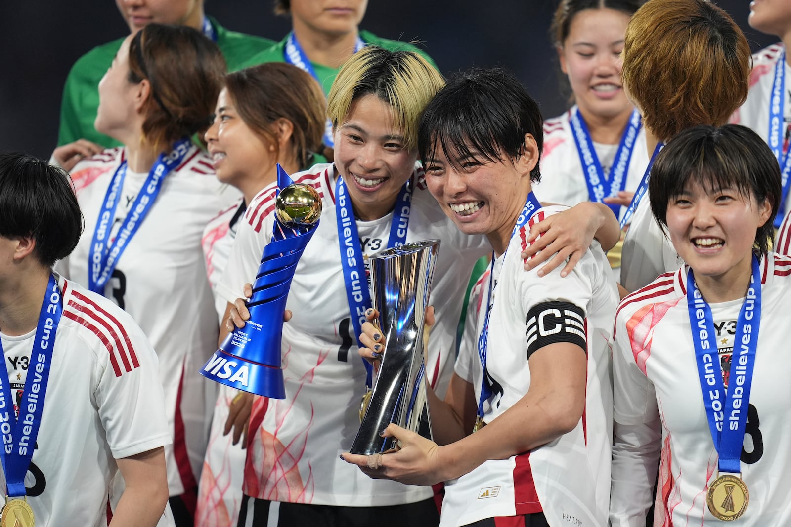 Japan defender Saki Kumagai, center right, holds the trophy as teammate forward Mina Tanaka holds her Most Valuable Player trophy after Japan defeated the United States to win the SheBelieves Cup women's soccer tournament Wednesday, Feb. 26, 2025, in San Diego. (AP Photo/Gregory Bull)