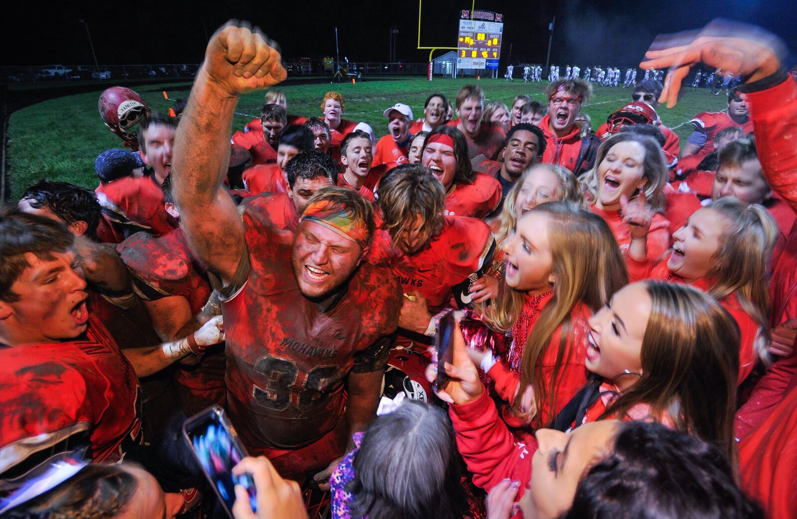 Madison players celebrate with their fans Friday night after defeating Anna 14-10 in the Division V, Region 20 playoffs at Brandenburg Field in Madison Township. NICK GRAHAM/STAFF