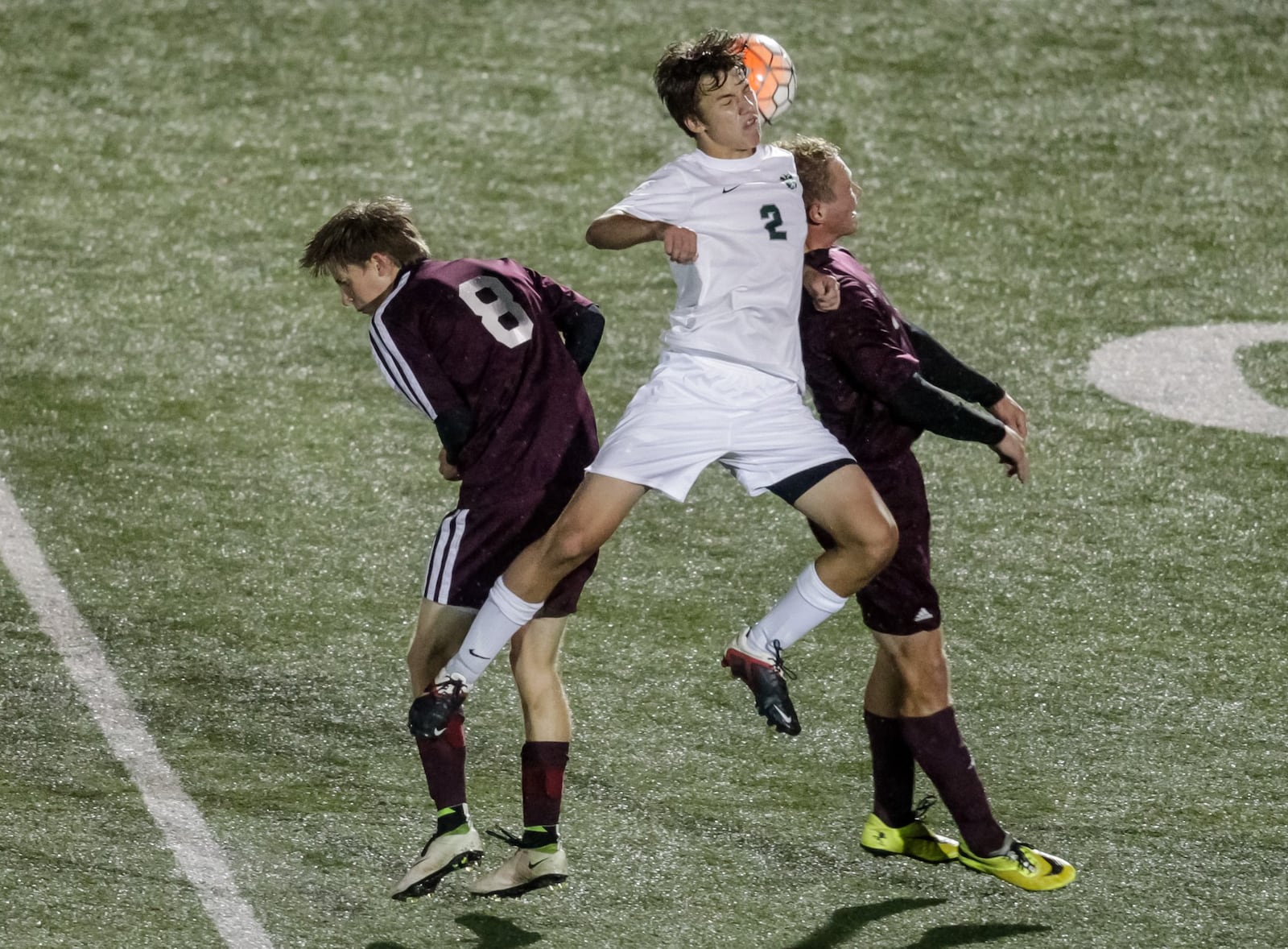 Badin’s John Hetterich jumps up for a header between Ross defenders Adam McCandless (left) and Michael Carroll (right) during the first half of their Division II sectional boys soccer game Oct. 20, 2016, at Monroe. NICK GRAHAM/STAFF