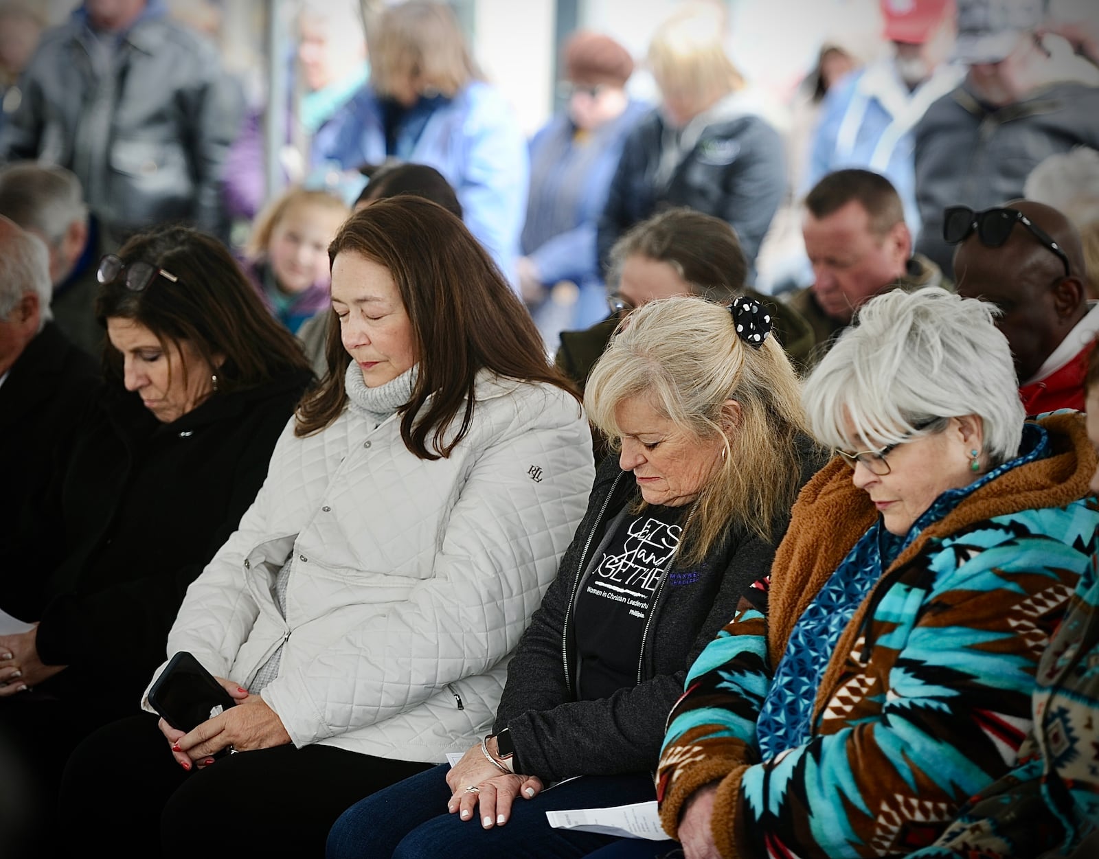 Audience members bow their heads in a moment of reflection during a ceremony Wednesday, April 3, 2024, marking the 50th anniversary of the devastating tornado that resulted in the deaths of 35 people and injured more than 1,300. MARSHALL GORBY\STAFF