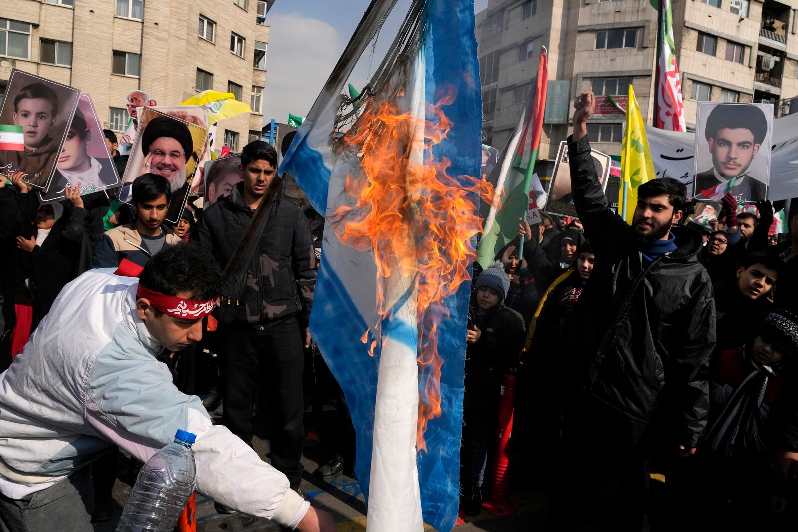 Iranian demonstrators burn a representation of the Israeli flag during a rally commemorating anniversary of 1979 Islamic Revolution that toppled the late pro-U.S. Shah Mohammad Reza Pahlavi and brought Islamic clerics to power, in Tehran, Iran, Monday, Feb. 10, 2025. (AP Photo/Vahid Salemi)