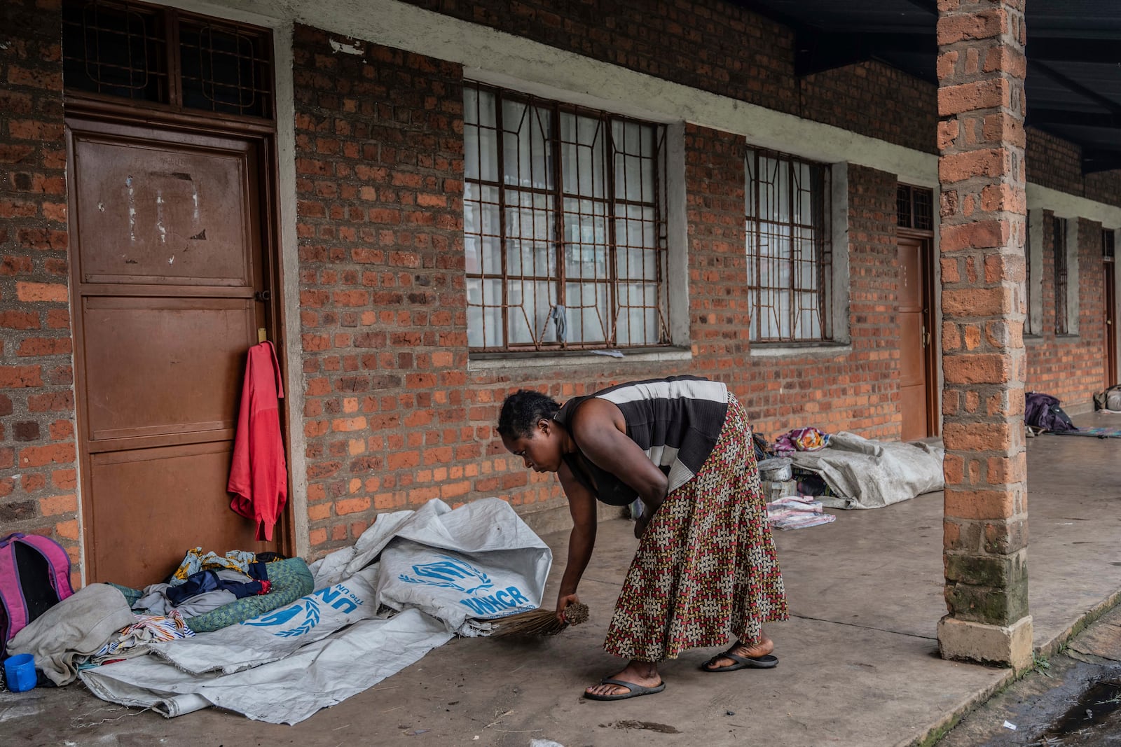 Zawadi Sifa, 35, mother of seven, who has been fleeing fighting from camp to camp, sweeps in her latest displaced camp in Goma, Democratic Republic of the Congo, Thursday, Feb. 5, 2025.(AP Photo/Moses Sawasawa)