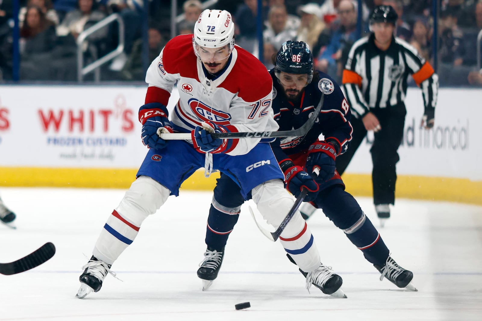 Montreal Canadiens defenseman Arber Xhekaj, left, chases the puck in front of Columbus Blue Jackets forward Kirill Marchenko during the first period of an NHL hockey game in Columbus, Ohio, Wednesday, Nov. 27, 2024. (AP Photo/Paul Vernon)