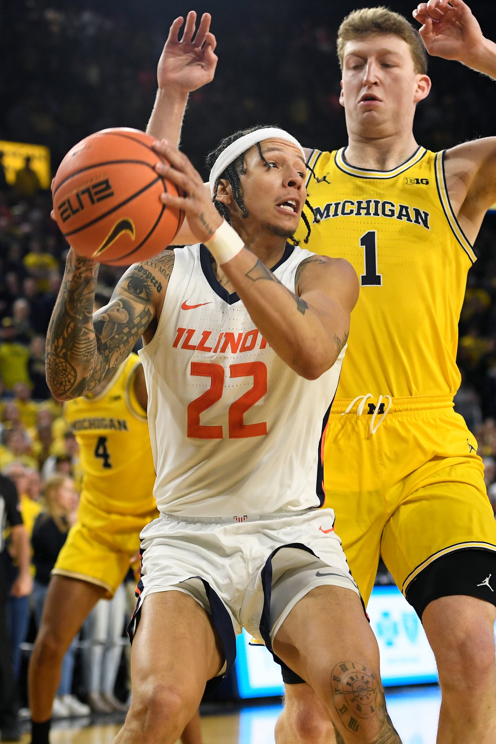 Illinois guard Tre White (22) tries to shoot the ball past Michigan forward Danny Wolf (1) during the first half of an NCAA college basketball game, Sunday, March 2, 2025, in Ann Arbor, Mich. (AP Photo/Jose Juarez)