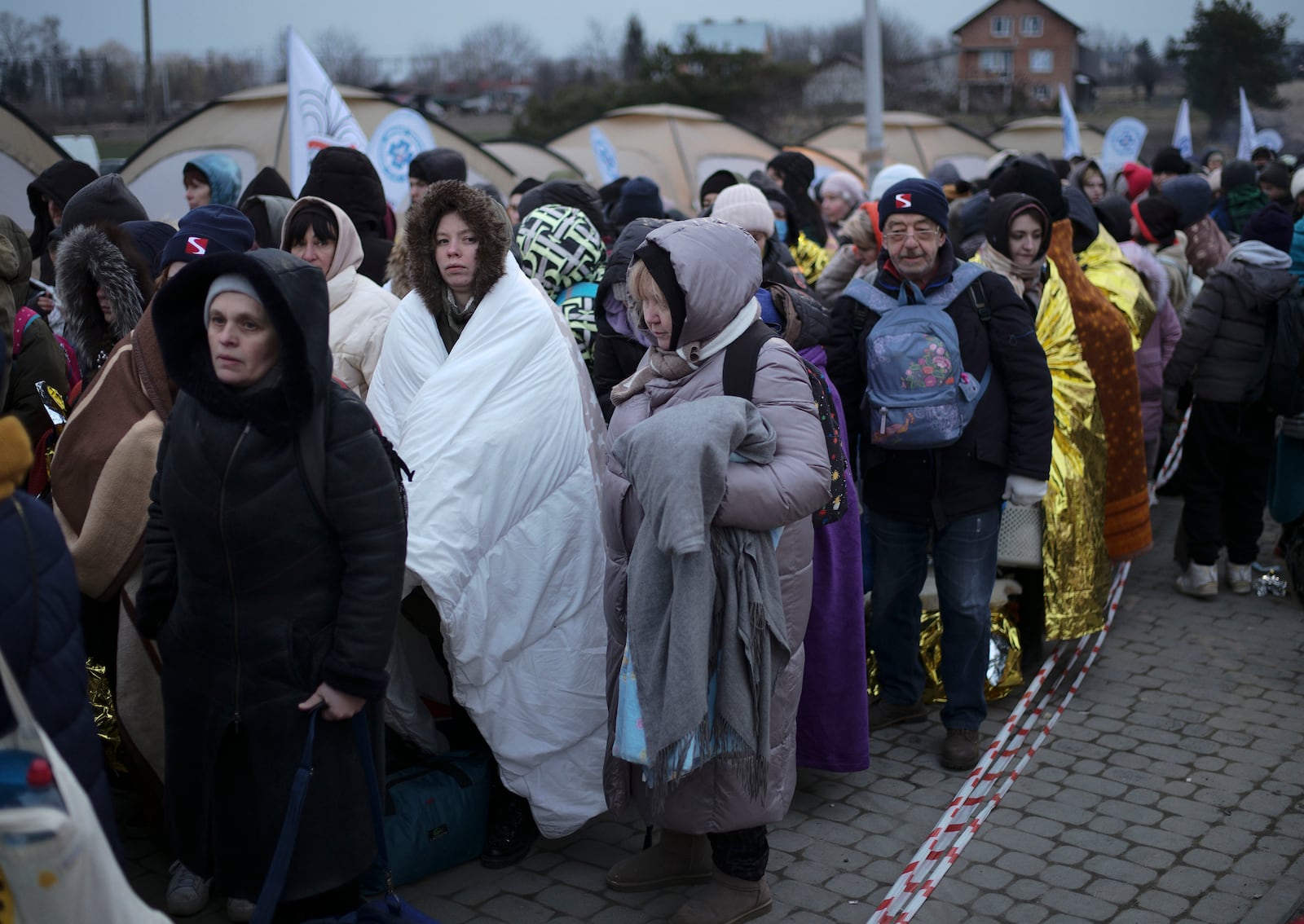 FILE - Refugees wait in a crowd for transportation after fleeing from the Ukraine and arriving at the border crossing in Medyka, Poland, March 7, 2022. (AP Photo/Markus Schreiber, File)