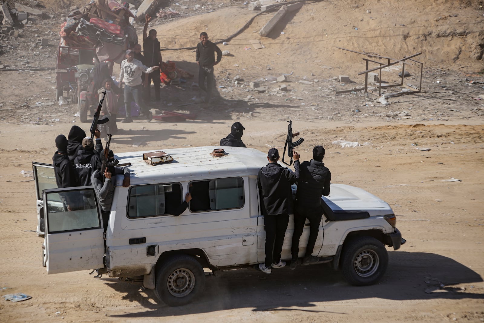 Hamas fighters secure aid trucks that arrived the Gaza Strip, in Rafah, Tuesday, Jan. 21, 2025, days after a ceasefire deal between Hamas and Israel went into effect. (AP Photo/Jehad Alshrafi)