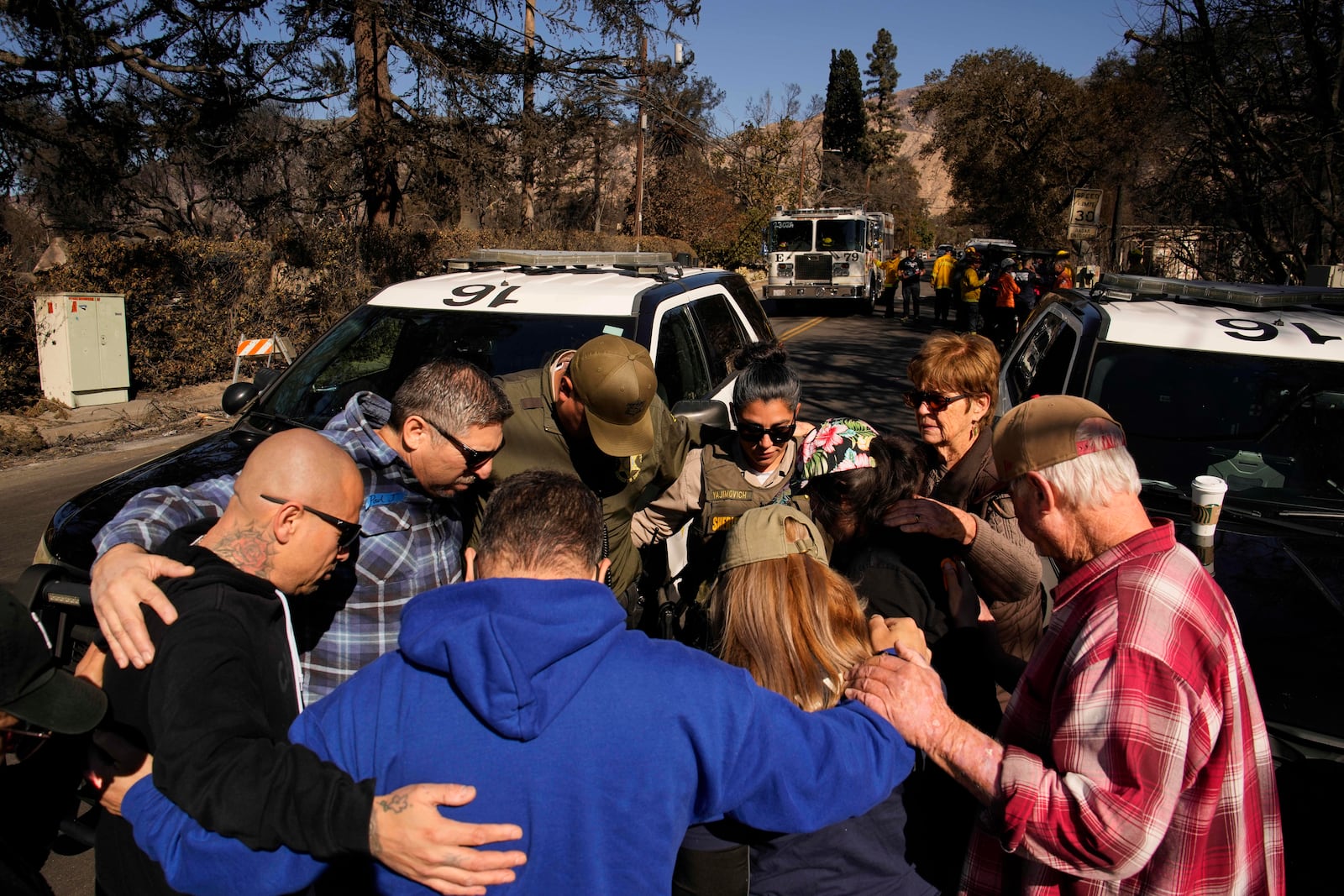 Members of Calvary Disaster Relief pray with some Los Angeles County sheriff's deputies, Wednesday, Jan. 15, 2025, in Altadena, Calif. (AP Photo/John Locher)